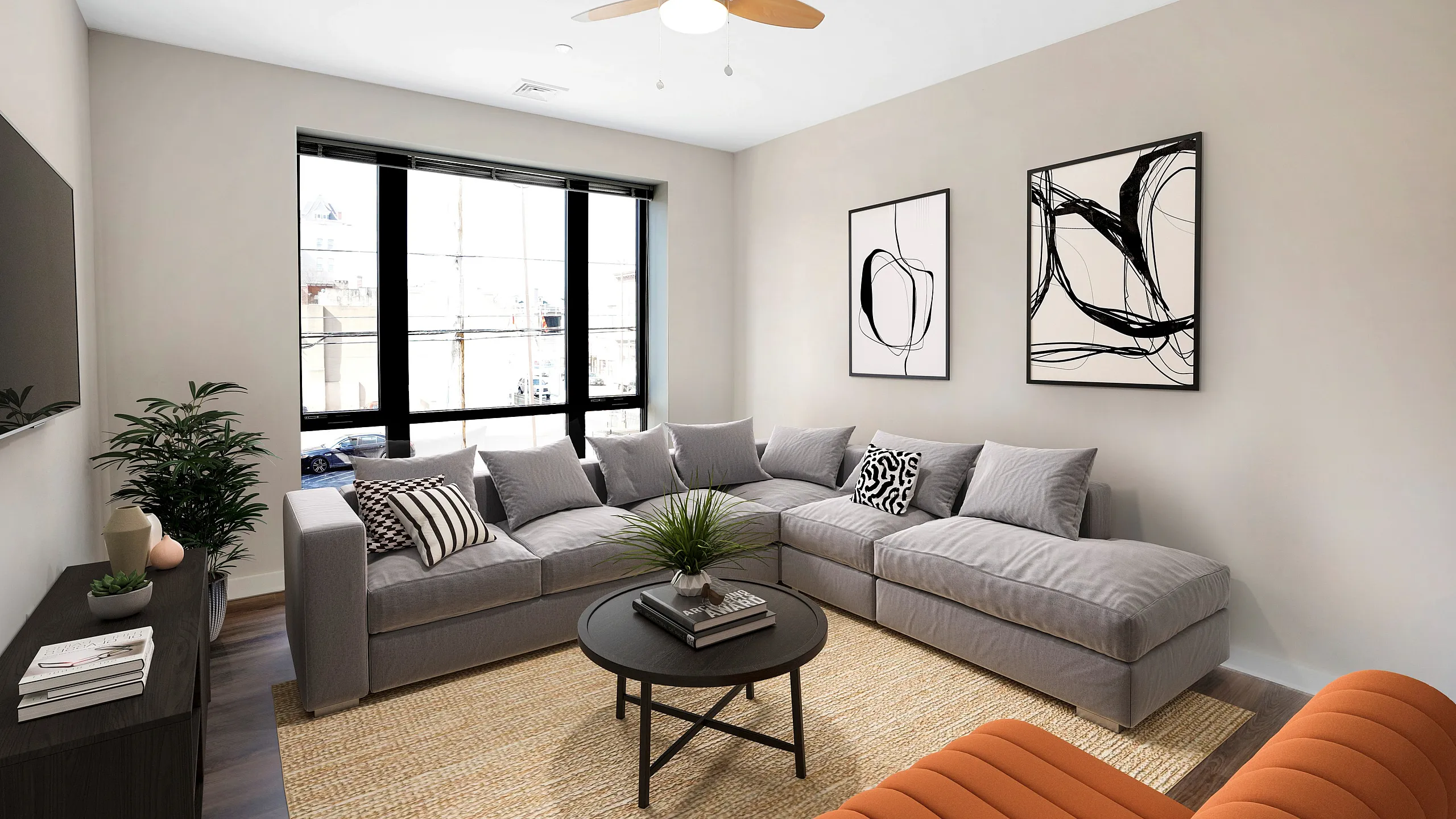 Modern apartment living room with a large gray sectional sofa, stylish abstract wall art, and bright natural lighting from floor-to-ceiling windows.