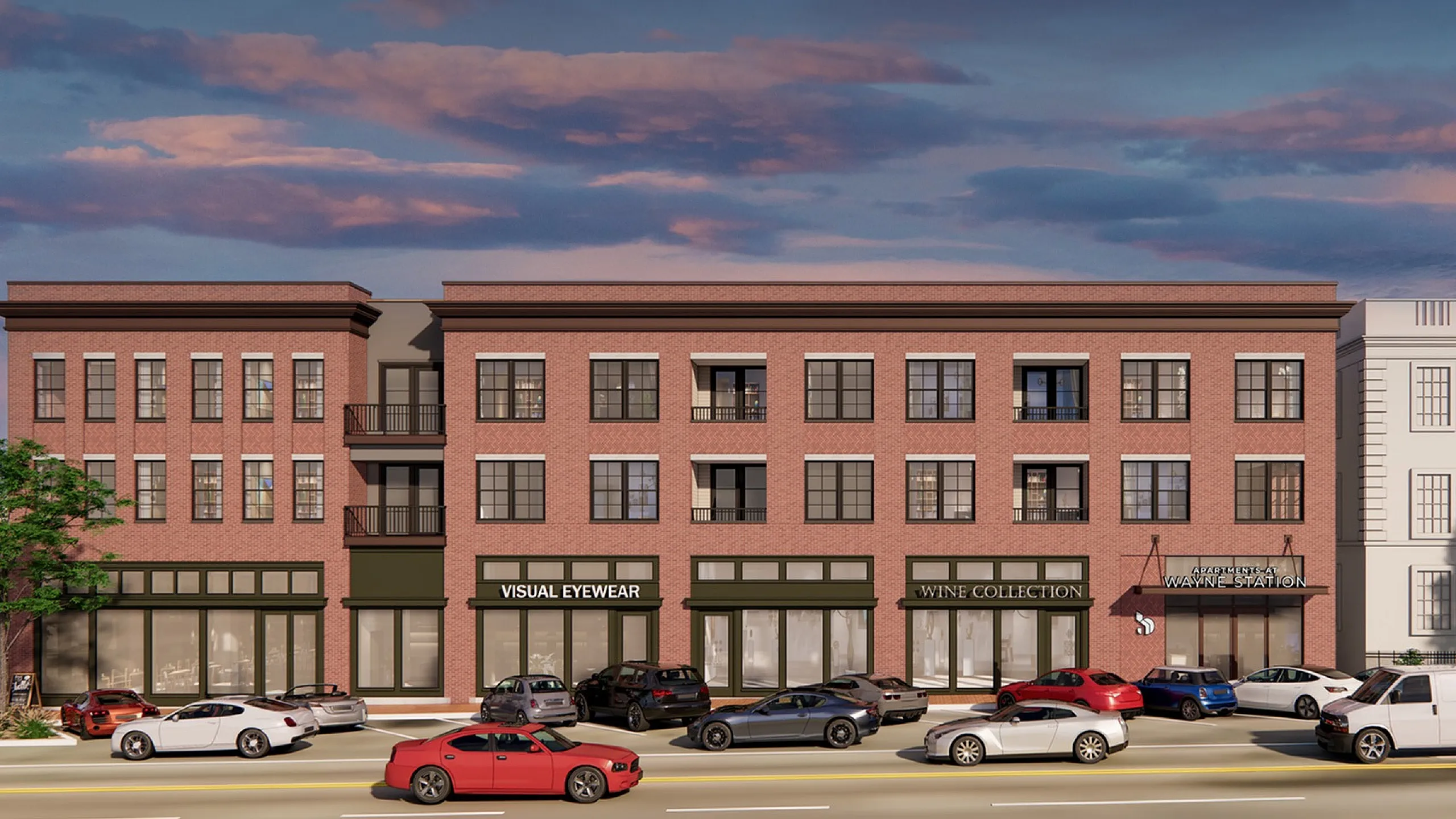 Charming brick building with modern storefronts and elegant residential units above, set against a picturesque evening sky.
