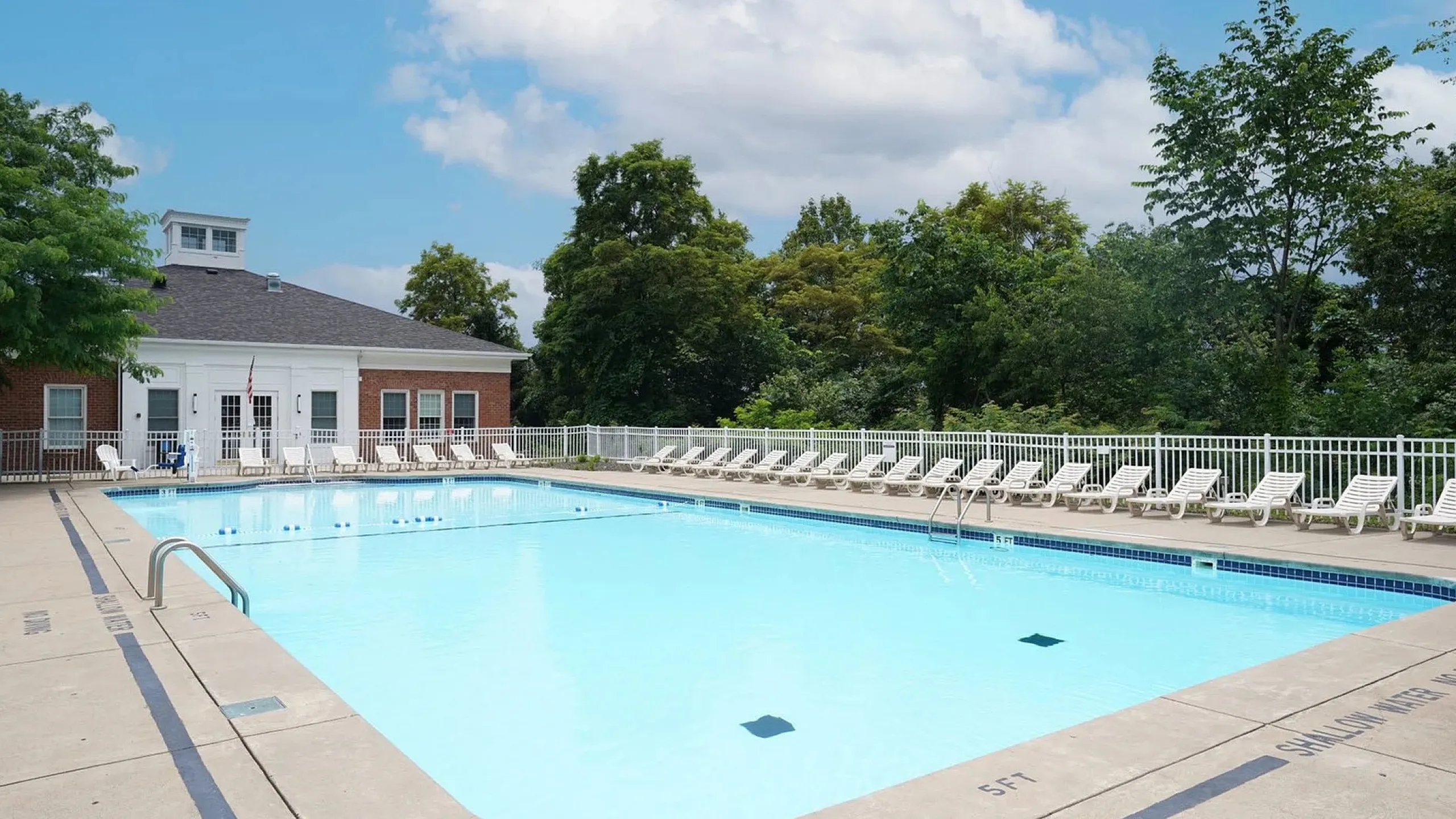 Inviting outdoor swimming pool with sun loungers and lush greenery, perfect for relaxation and leisure.