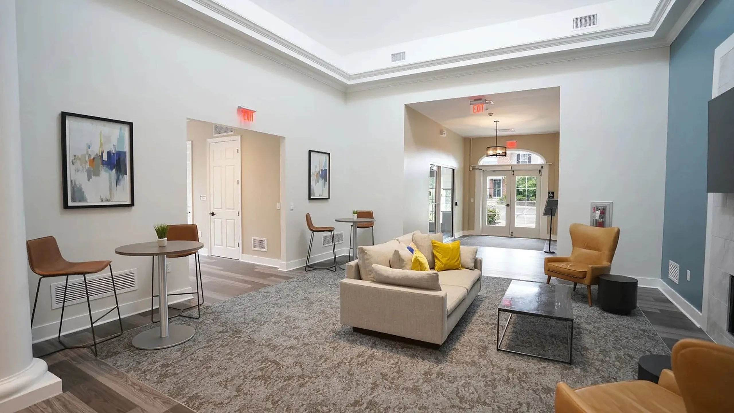 Inviting living space with modern decor, cozy seating, and natural light, featuring stylish design elements and plush carpeting.
