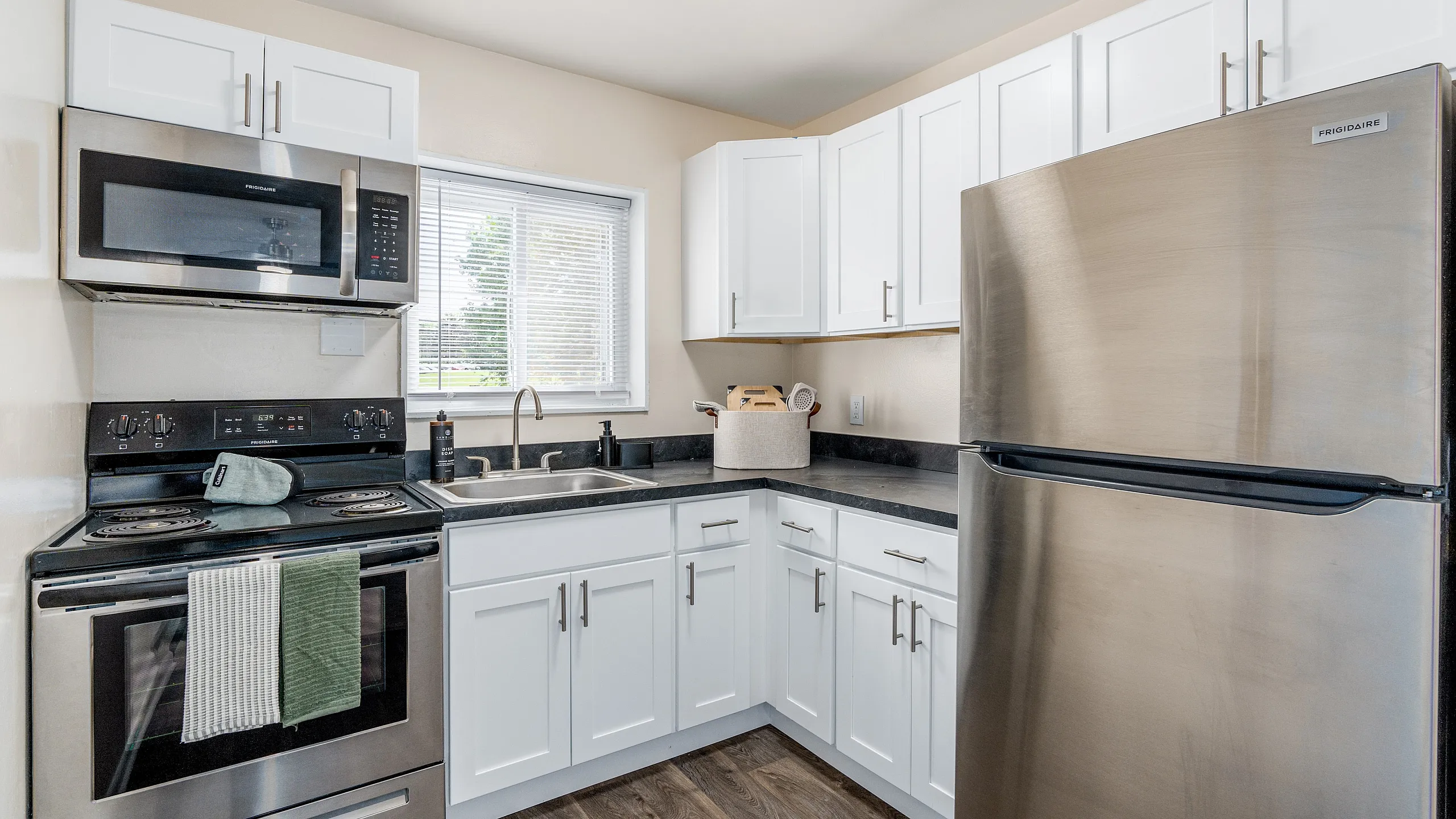 Modern kitchen with sleek stainless steel appliances, elegant white cabinetry, and abundant natural light.