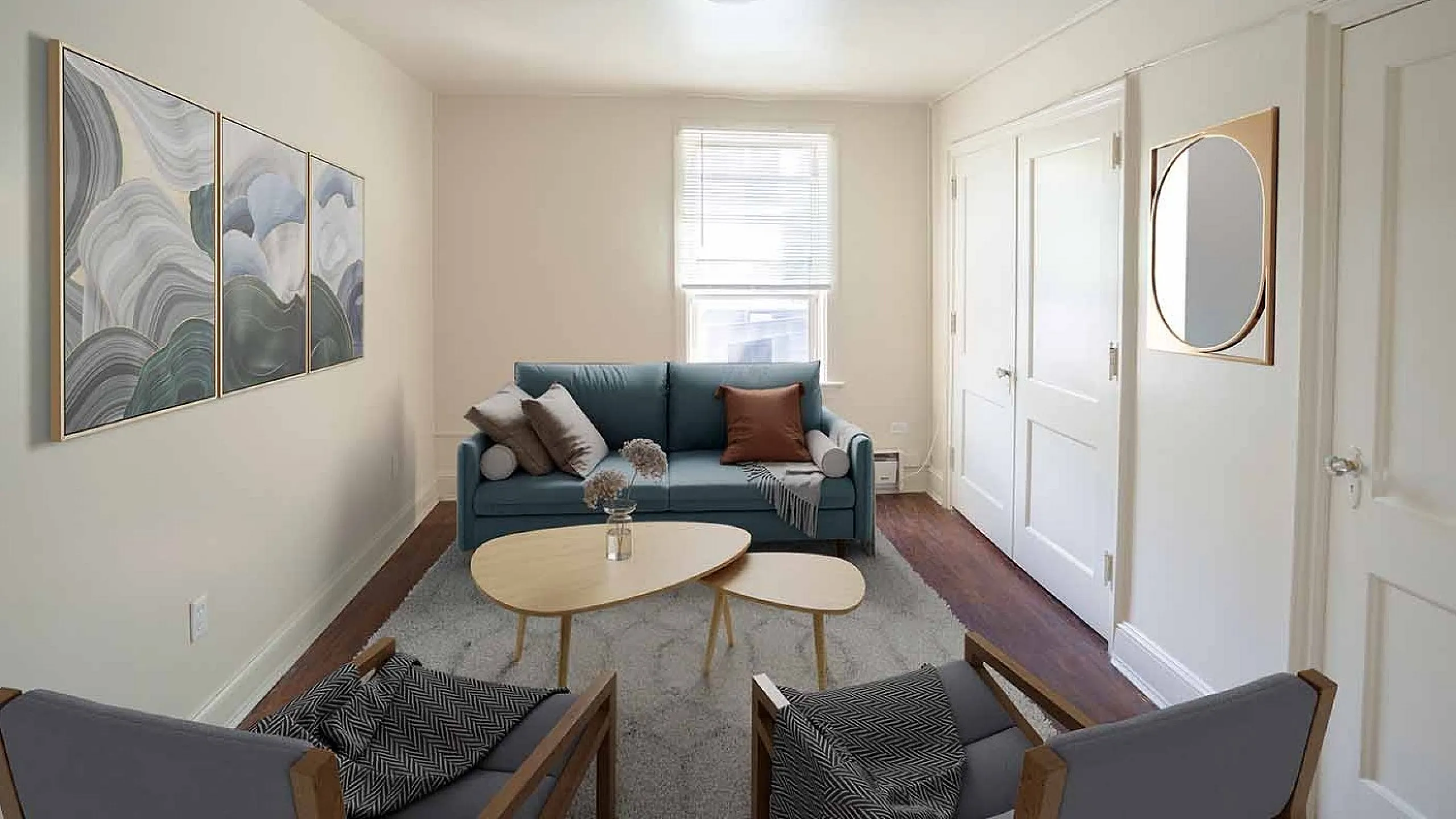 Chic contemporary living room with a plush blue sofa, elegant abstract art, and sleek Scandinavian-style furniture, creating a warm and inviting atmosphere.