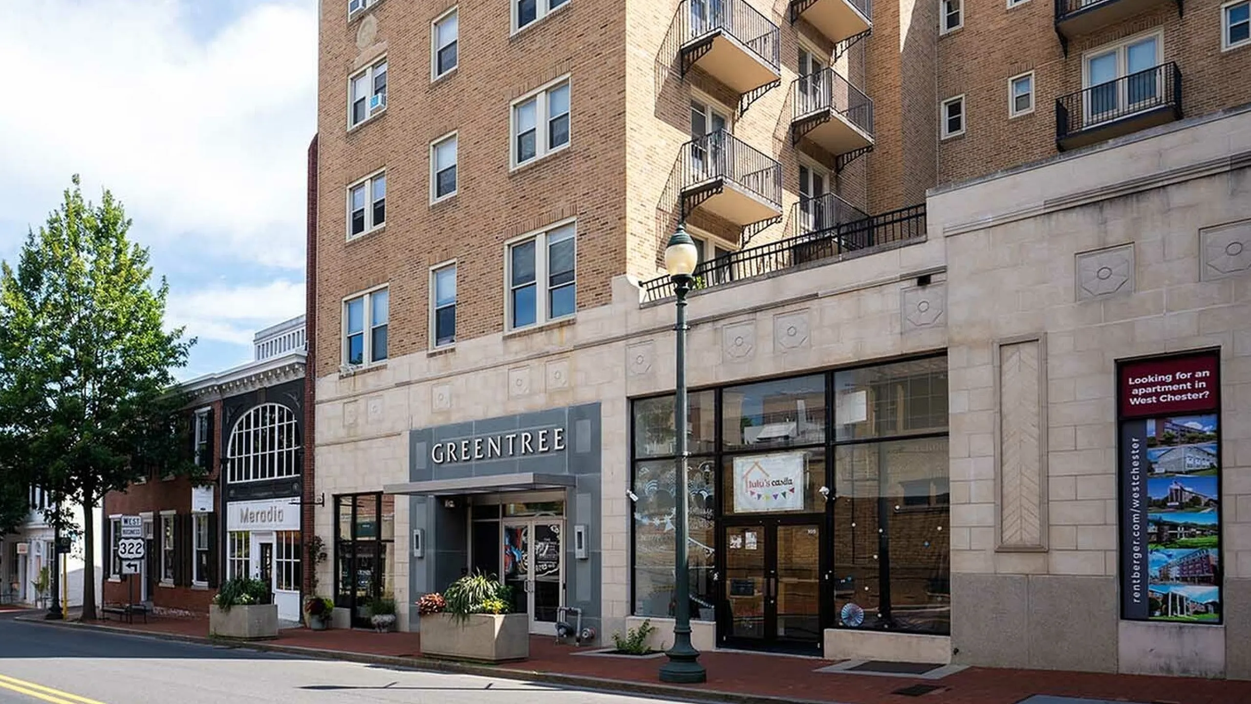 Charming urban apartment building with classic brick facade and inviting balconies, centrally located in West Chester.
