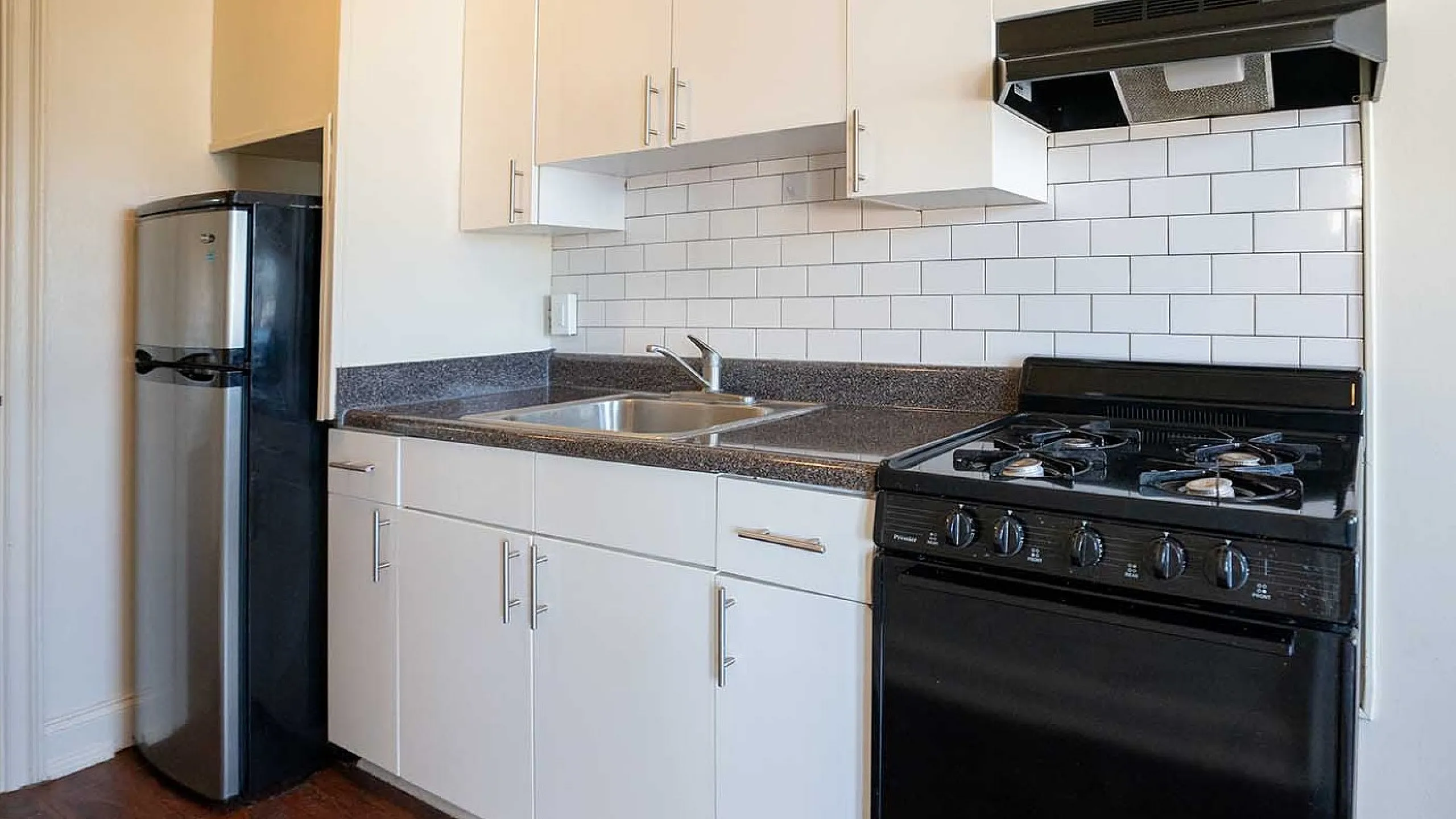 Modern kitchen with sleek stainless steel appliances, stylish white cabinets, and chic subway tile backsplash.