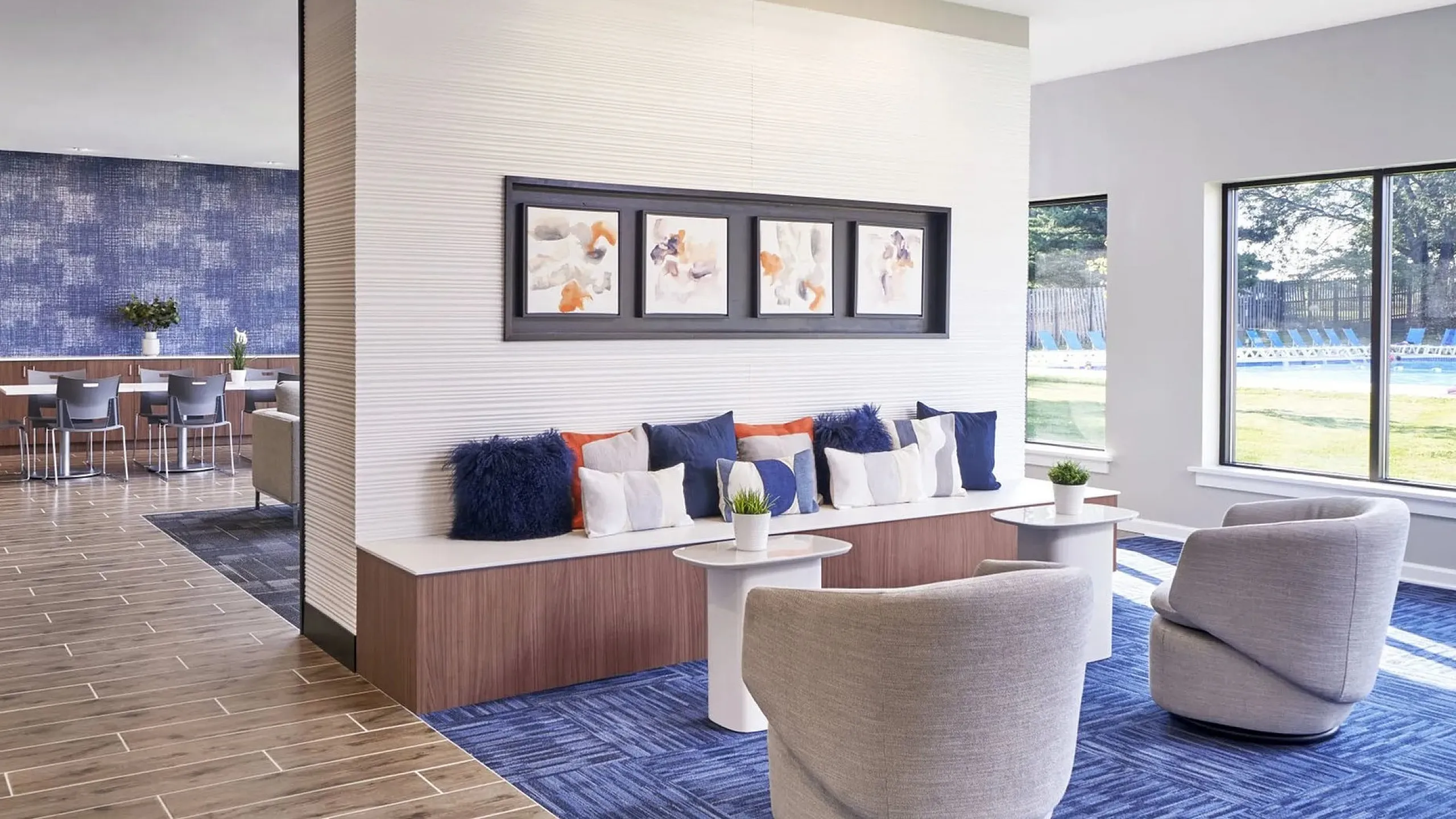 Modern lounge area with elegant seating, stylish decor, and large windows offering a bright, inviting atmosphere.