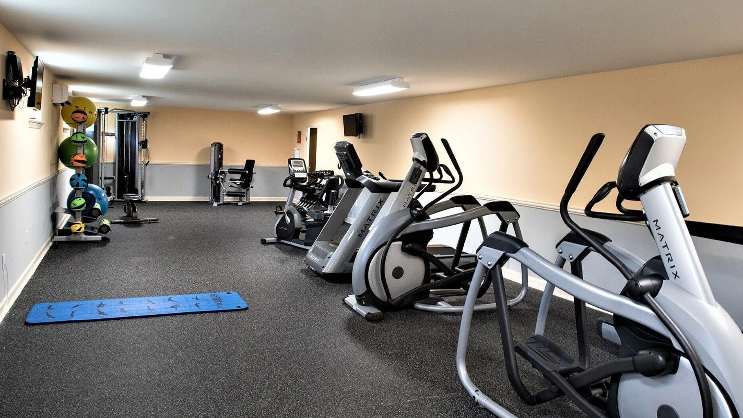 Modern fitness center equipped with state-of-the-art exercise machines and vibrant yoga mats, creating a vibrant space for an active lifestyle.