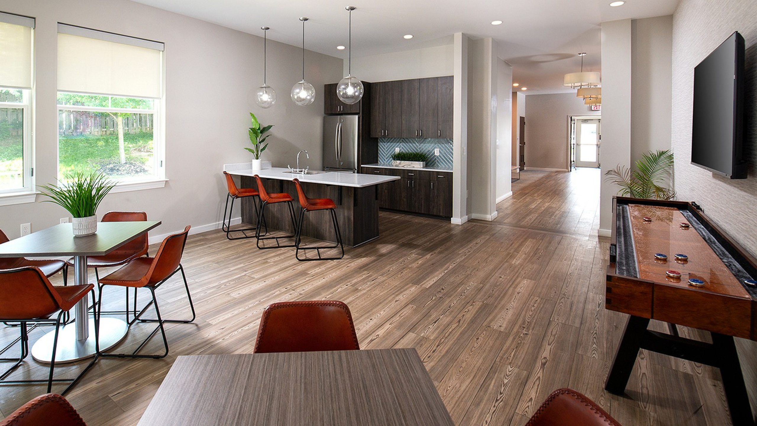 Modern open-concept apartment with elegant kitchen island, sleek pendant lighting, and stylish dining area perfect for entertaining.