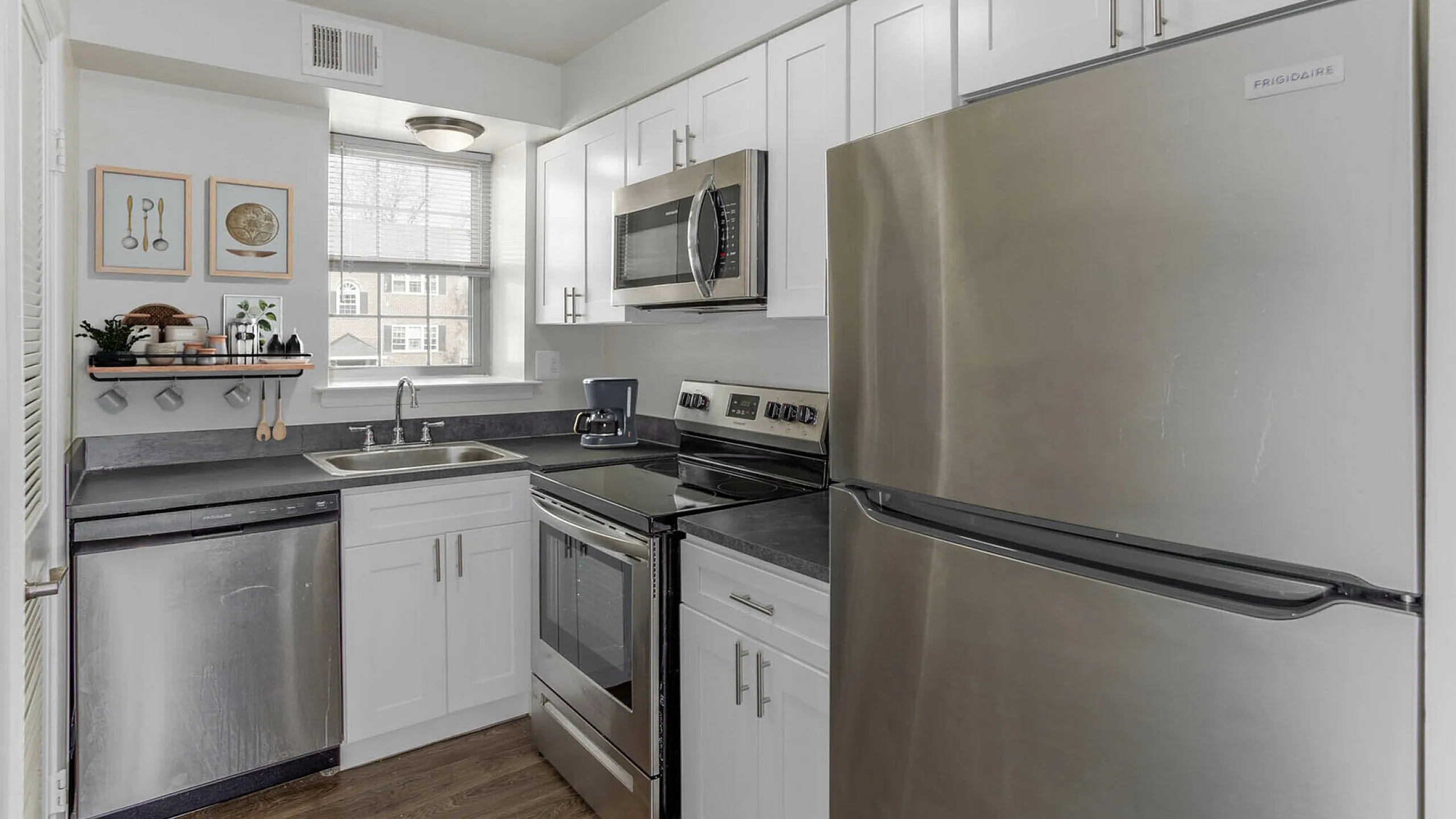 Modern kitchen featuring sleek stainless steel appliances, white cabinetry, and a stylish countertop design.