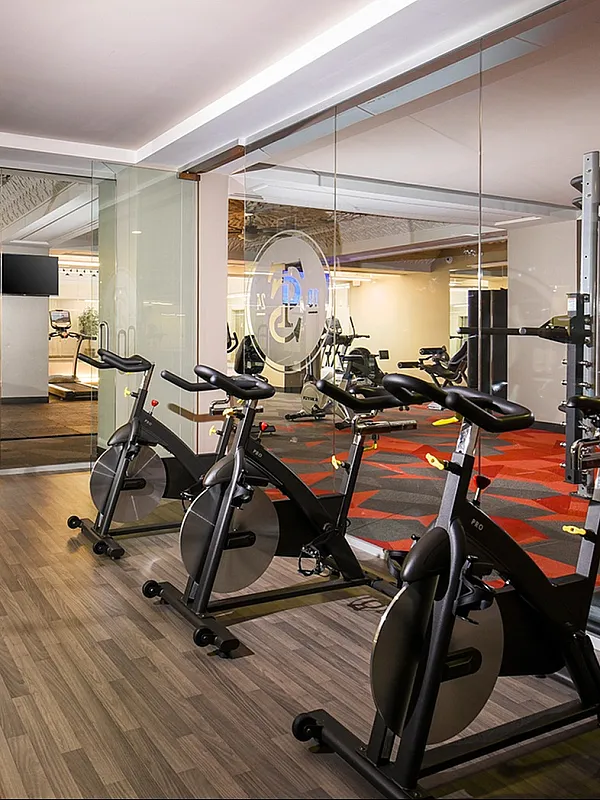 Modern apartment gym featuring state-of-the-art equipment, vibrant flooring, and a mirrored wall for a spacious feel.