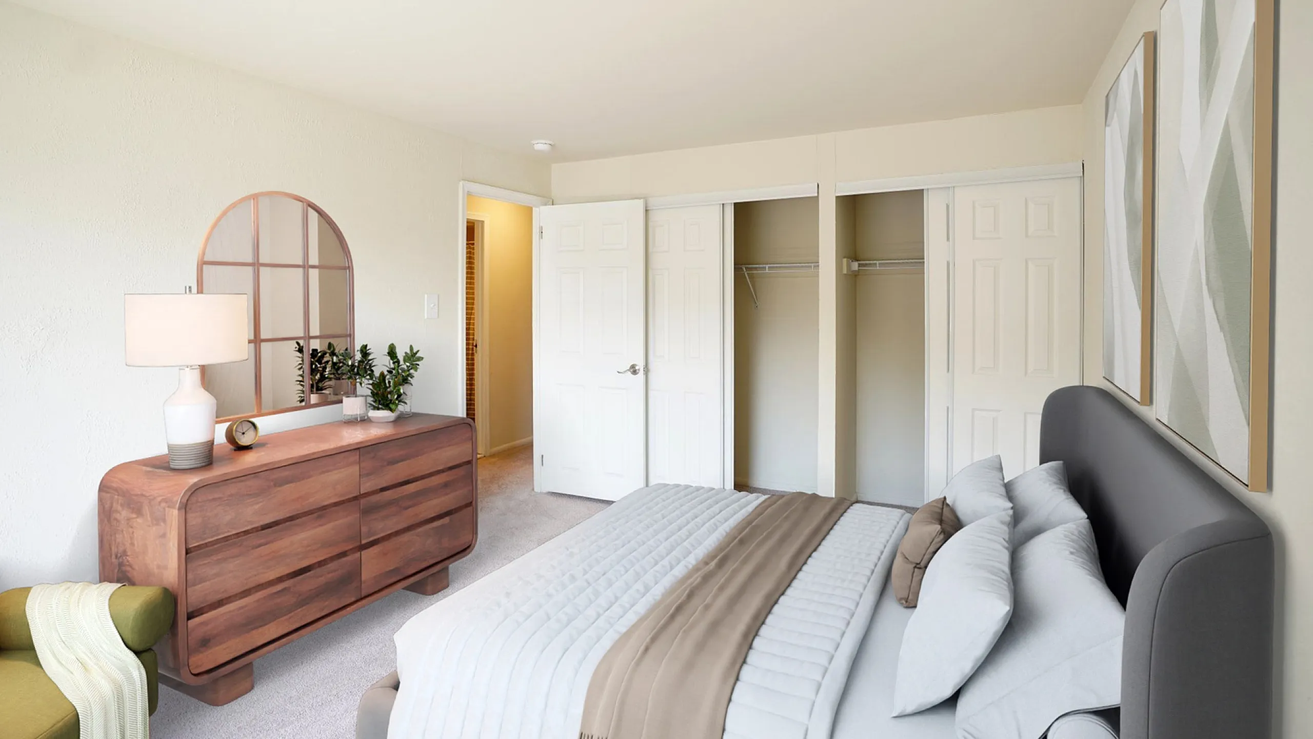 Elegant bedroom featuring a cozy bed, modern dresser with mirror, and spacious closet in a warm, inviting atmosphere.