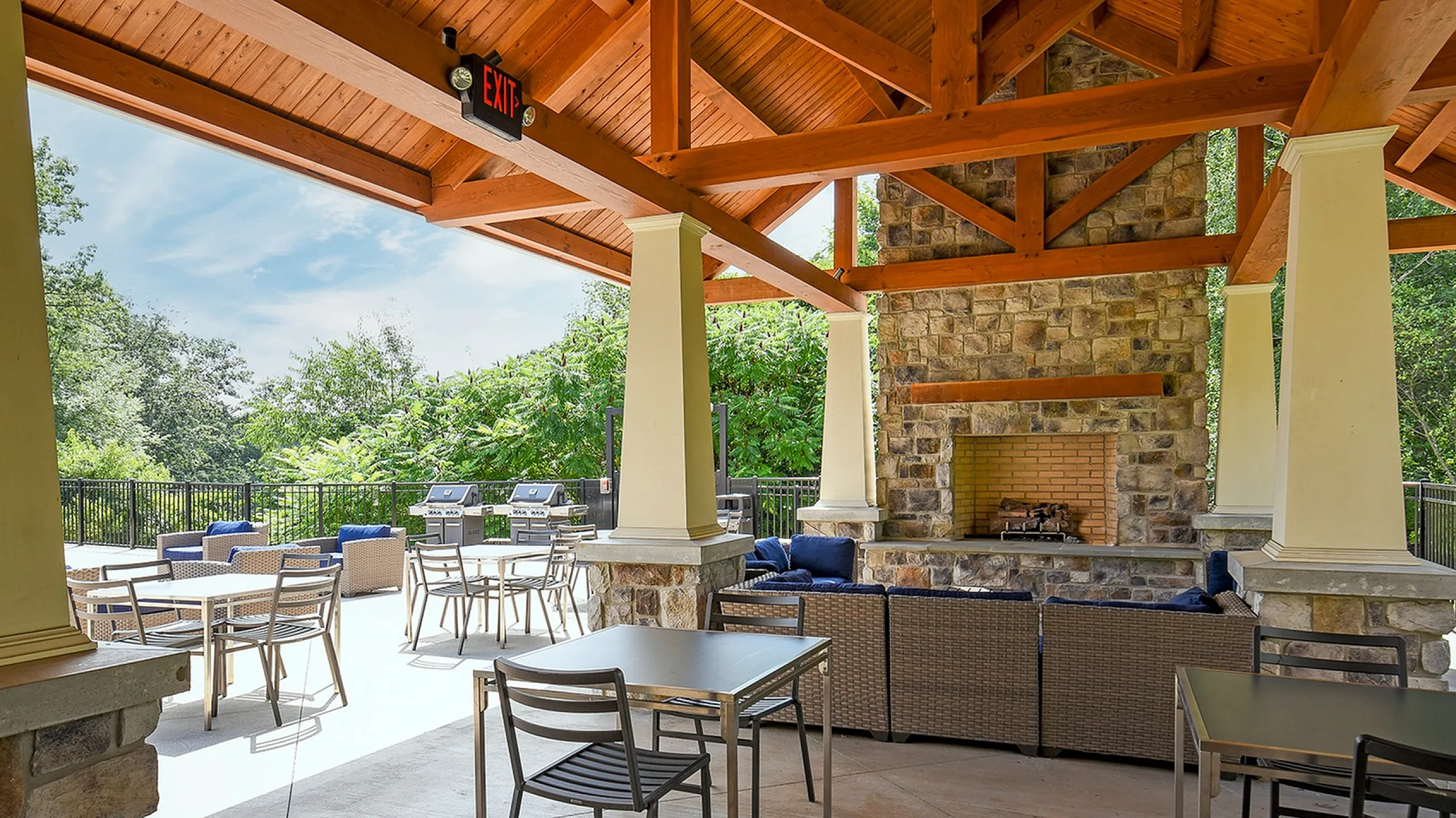 Charming outdoor patio with cozy seating, stone fireplace, and scenic views, perfect for relaxation and entertaining.