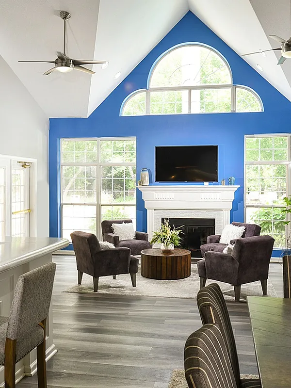 Bright and airy living room with vaulted ceilings, modern furnishings, and a vibrant blue accent wall.