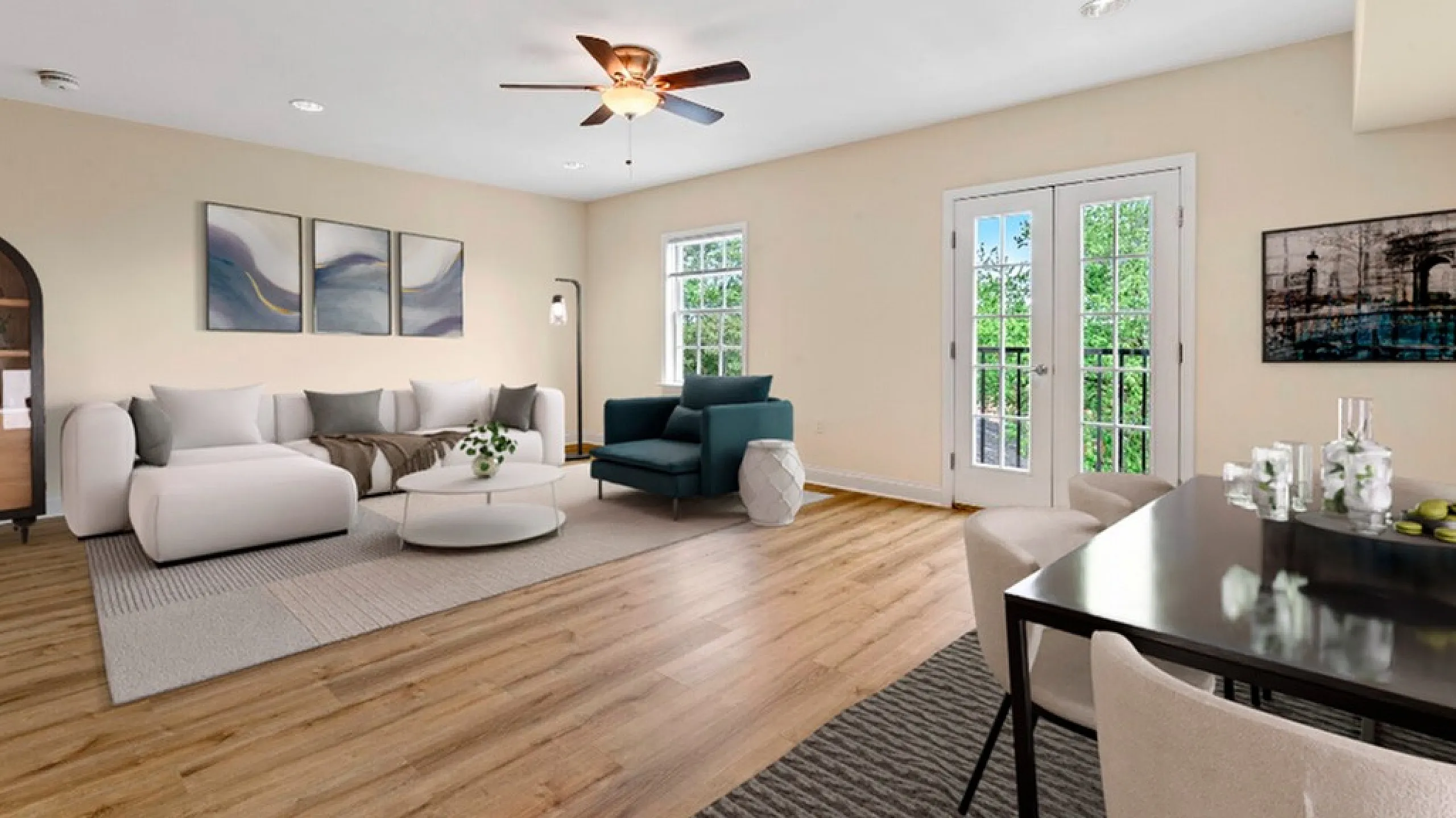 Bright and airy living room with modern decor, featuring a cozy sofa, elegant art pieces, and French doors opening to a scenic view.