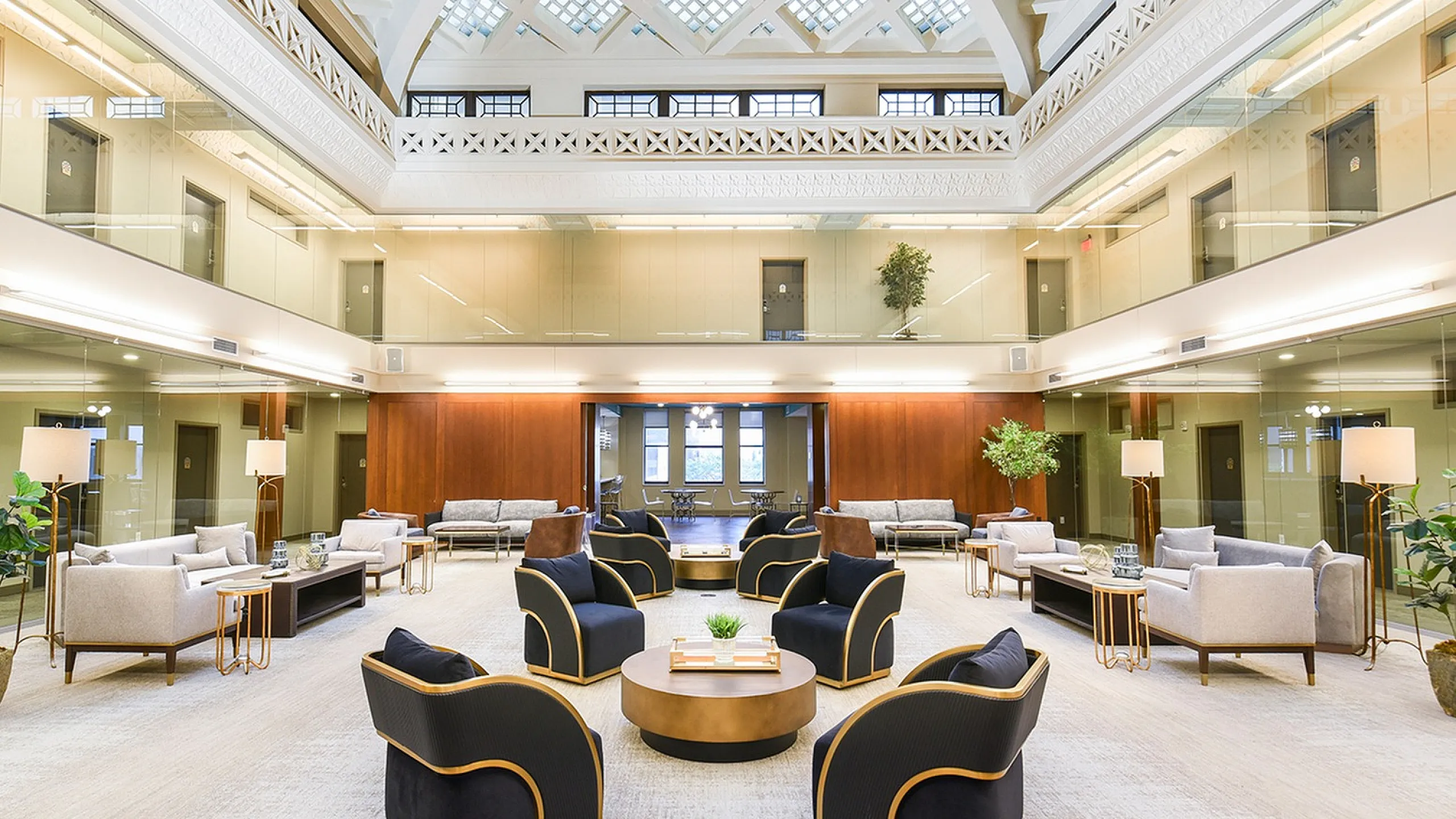 Elegant lounge area with plush seating, stylish decor, and high ceilings under a stunning geometric skylight.