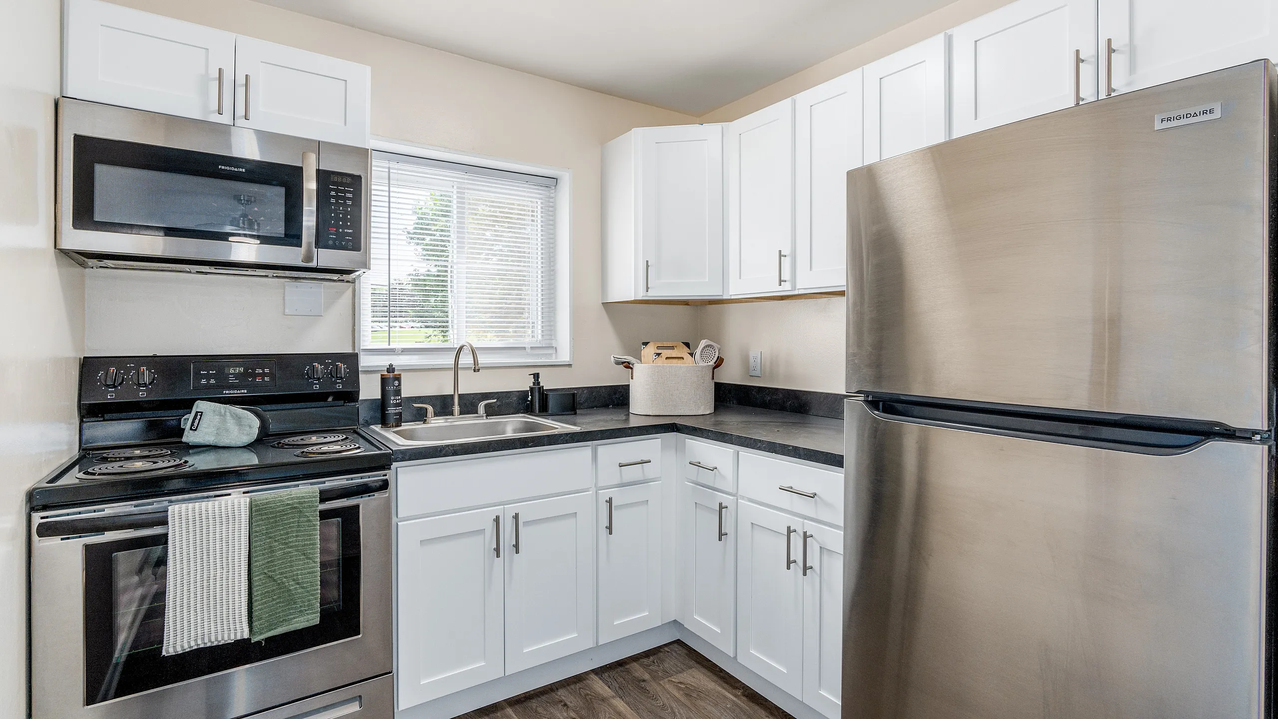 Modern kitchen with sleek stainless steel appliances, white cabinetry, and spacious countertops in a bright, inviting space.