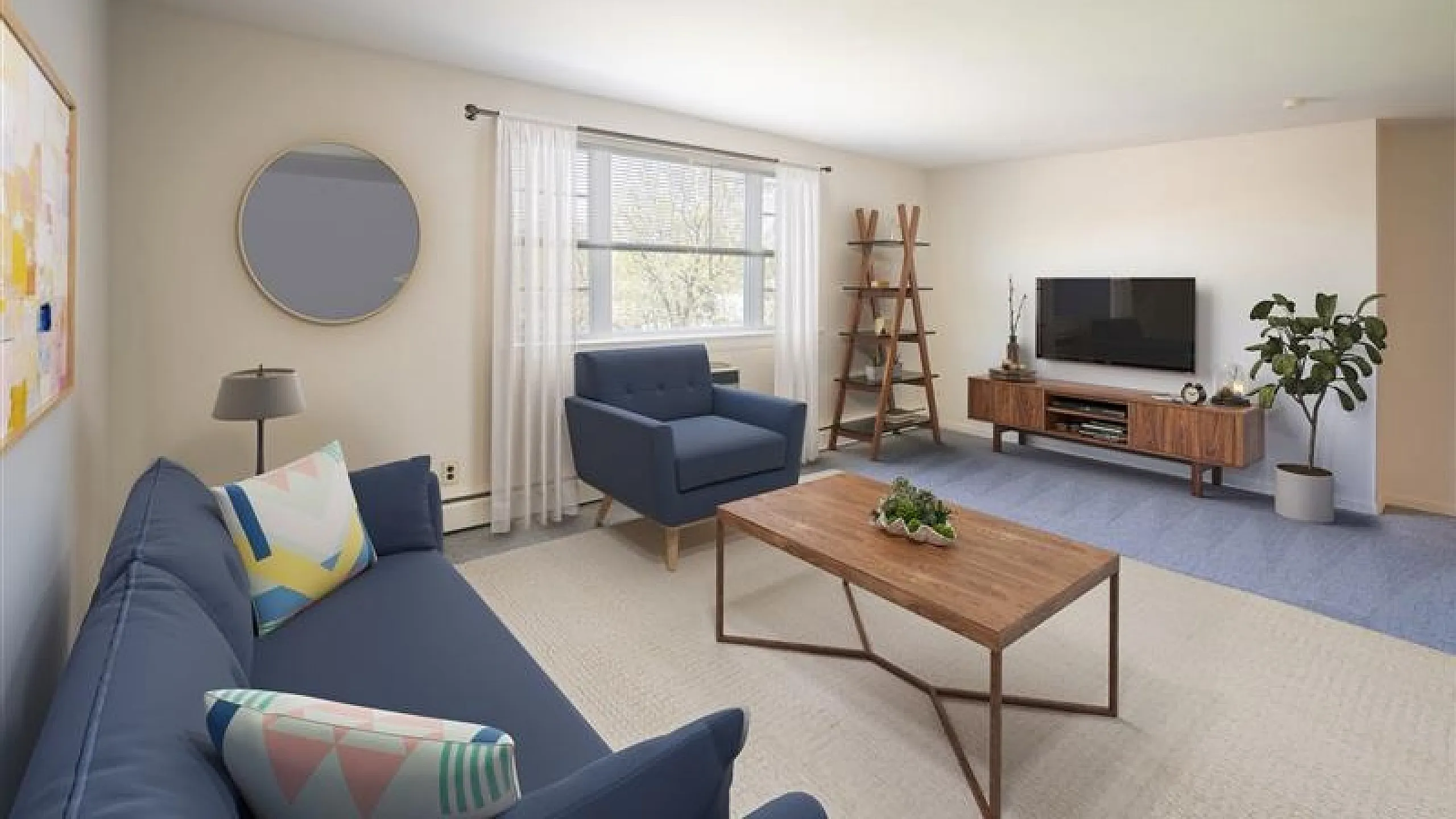 Chic living room with a modern blue sofa, stylish armchair, and sleek wooden coffee table, complemented by a TV unit and natural light from a large window.