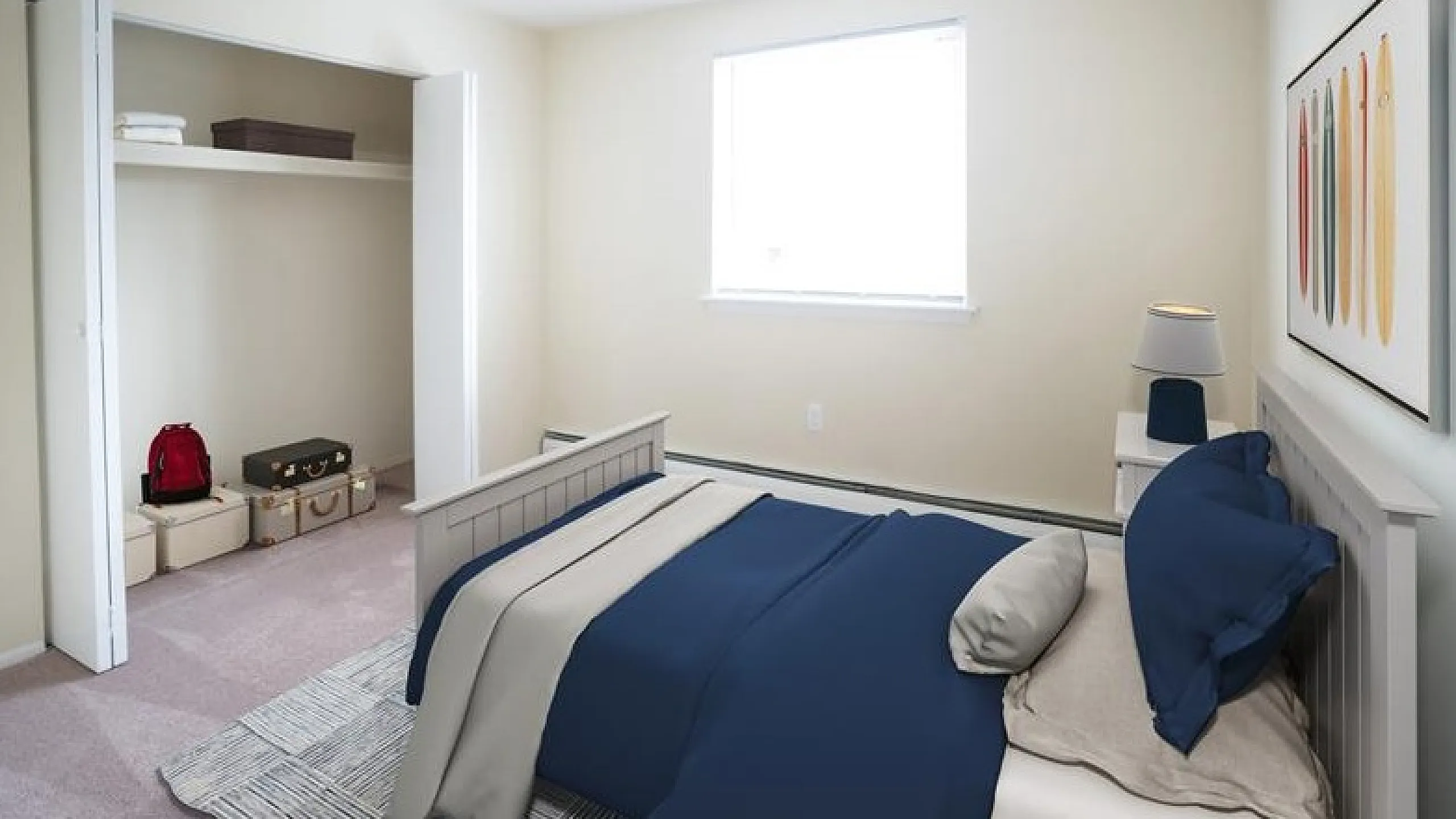 Cozy bedroom with chic navy bedding, bright window, spacious closet, and modern decor.
