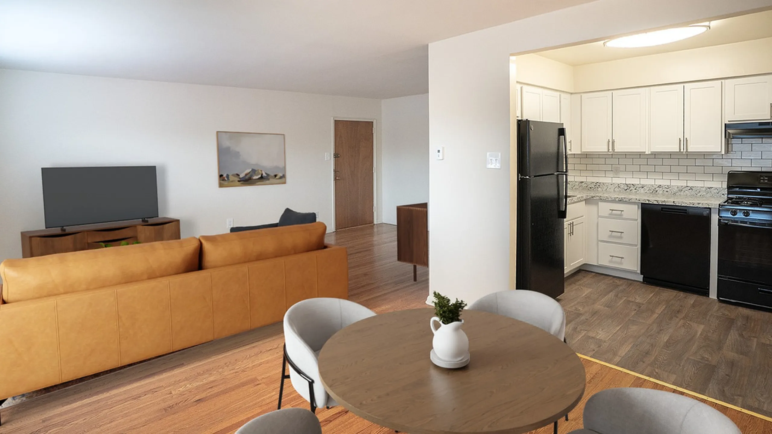 Inviting open-concept apartment with a cozy living room, modern kitchen with sleek black appliances, and an elegant dining area.