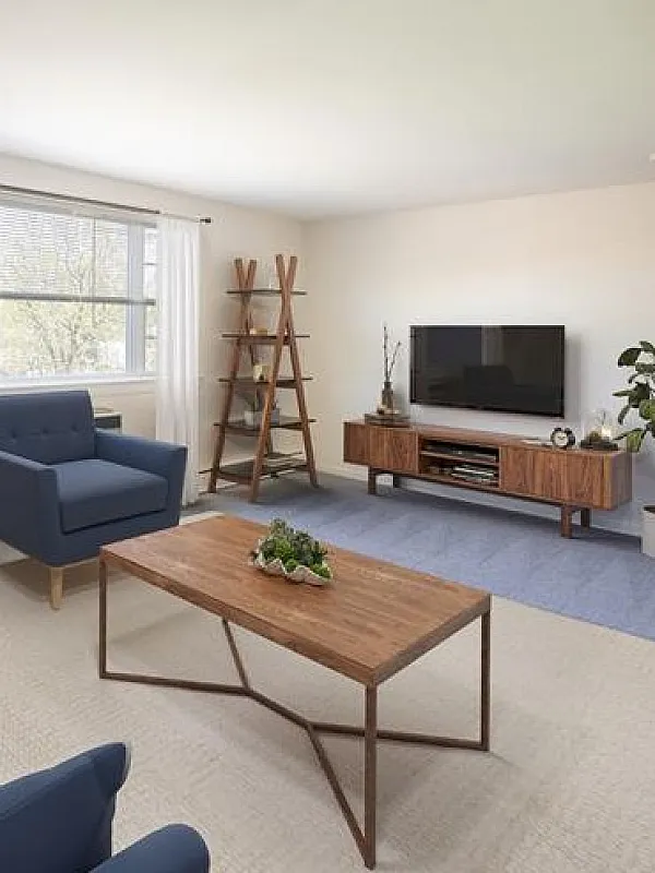 Chic and inviting living room with modern furniture, vibrant cushions, and large window offering natural light. Ideal for relaxation and entertainment.