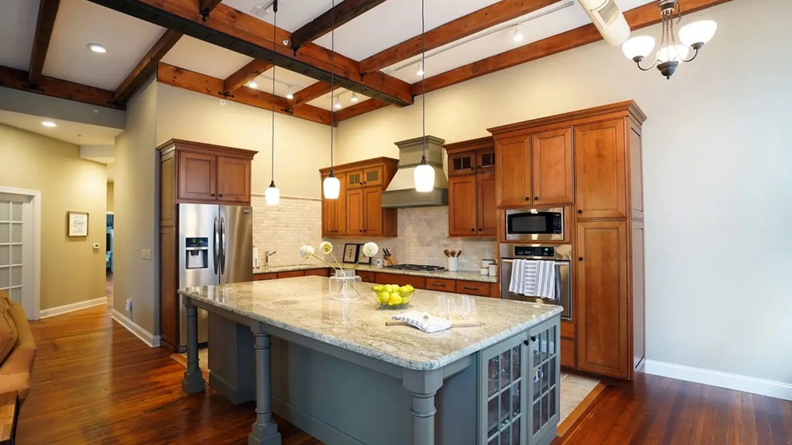 Charming kitchen with wooden beams, elegant cabinetry, and a spacious island offering modern comfort and style.