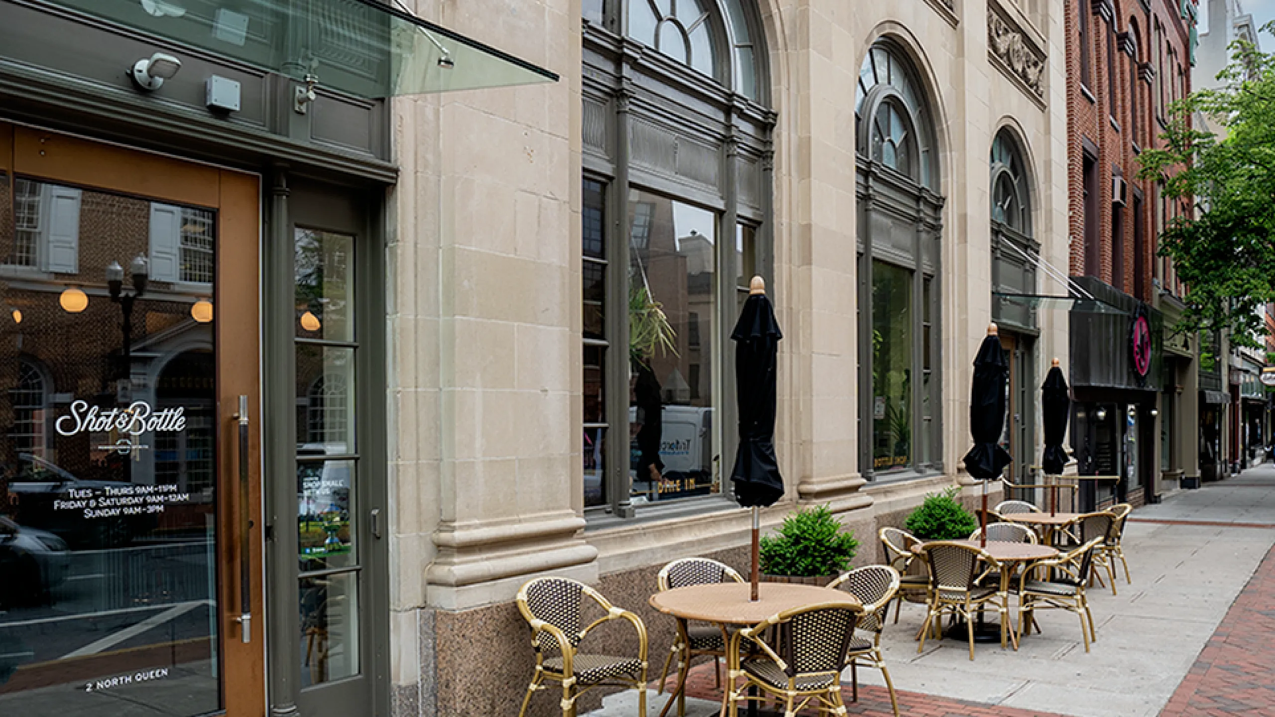 Charming urban caf&eacute; with elegant architecture and inviting outdoor seating on a lively city street.