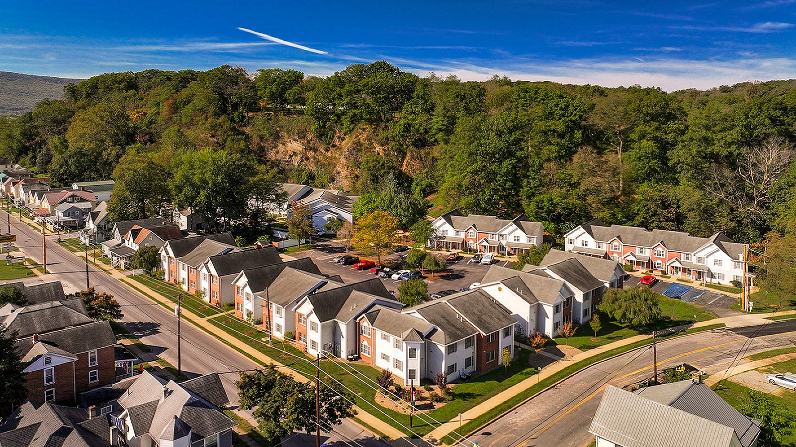 Charming residential community nestled in lush greenery, featuring modern townhouses along quiet streets, perfect for serene suburban living.