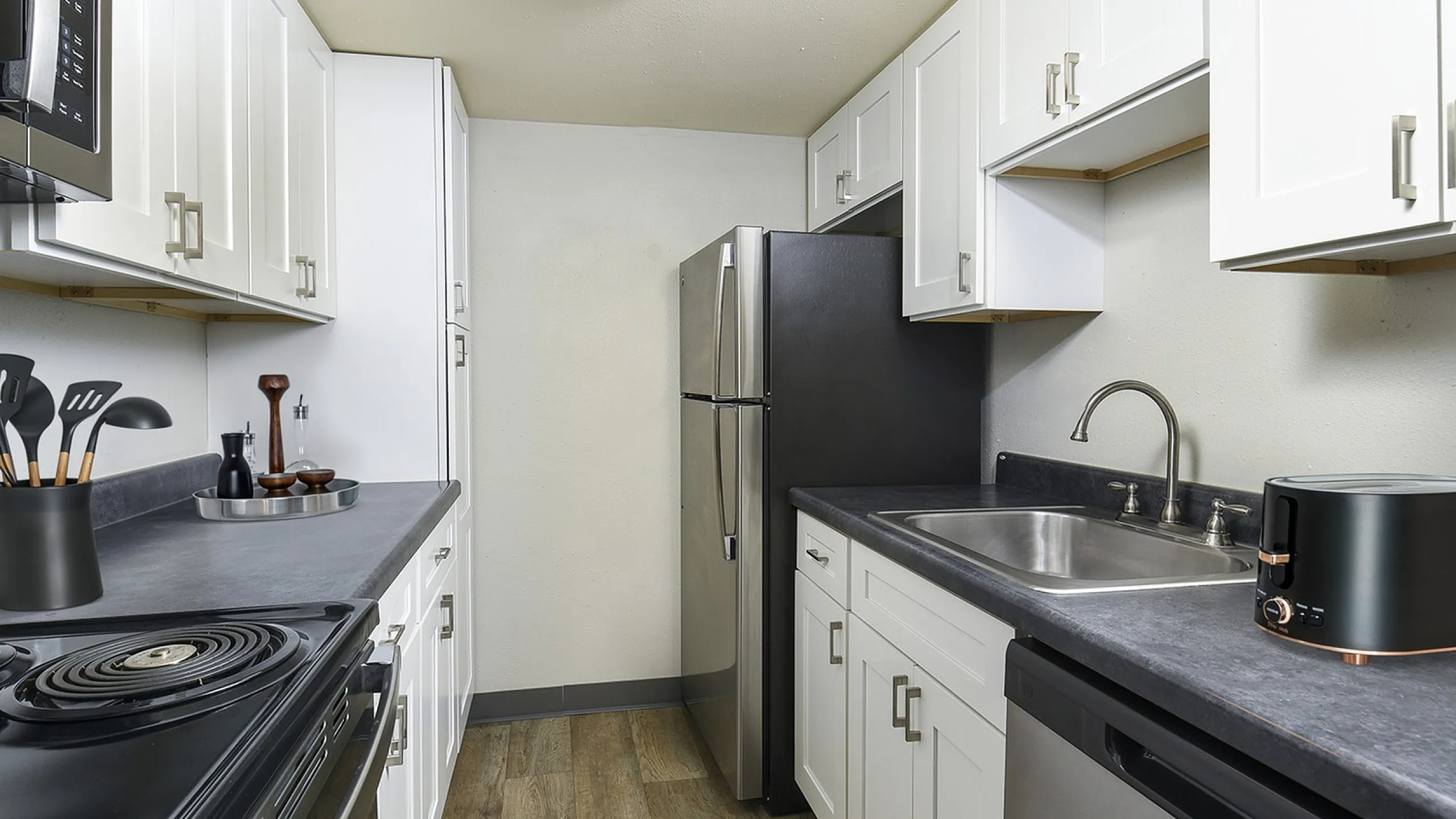 Chic modern kitchen with sleek stainless steel appliances, elegant white cabinetry, and contemporary fixtures, ideal for culinary creativity.