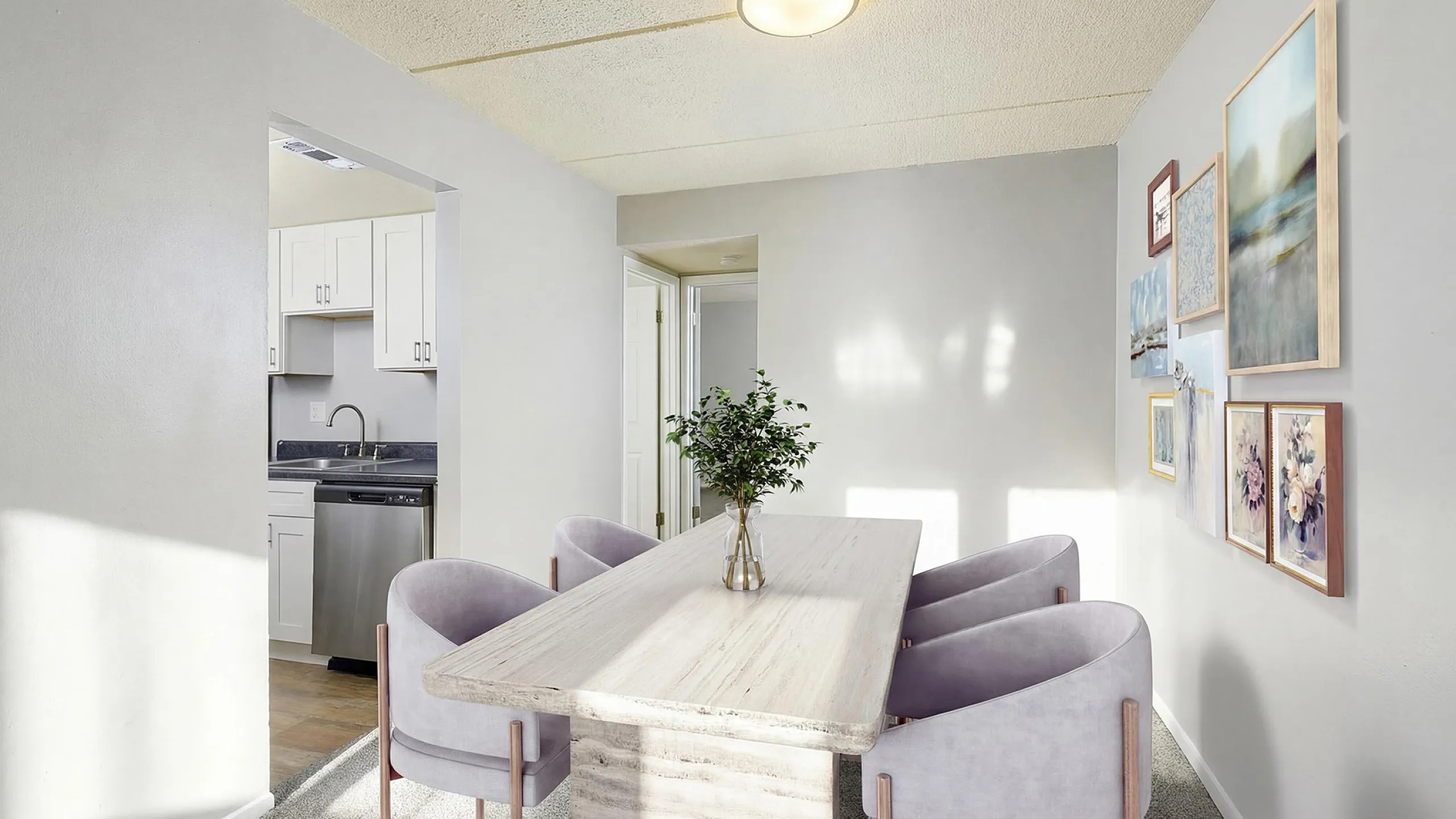 Chic dining area with elegant decor, contemporary table, and plush chairs, adjacent to a modern kitchen with white cabinetry.