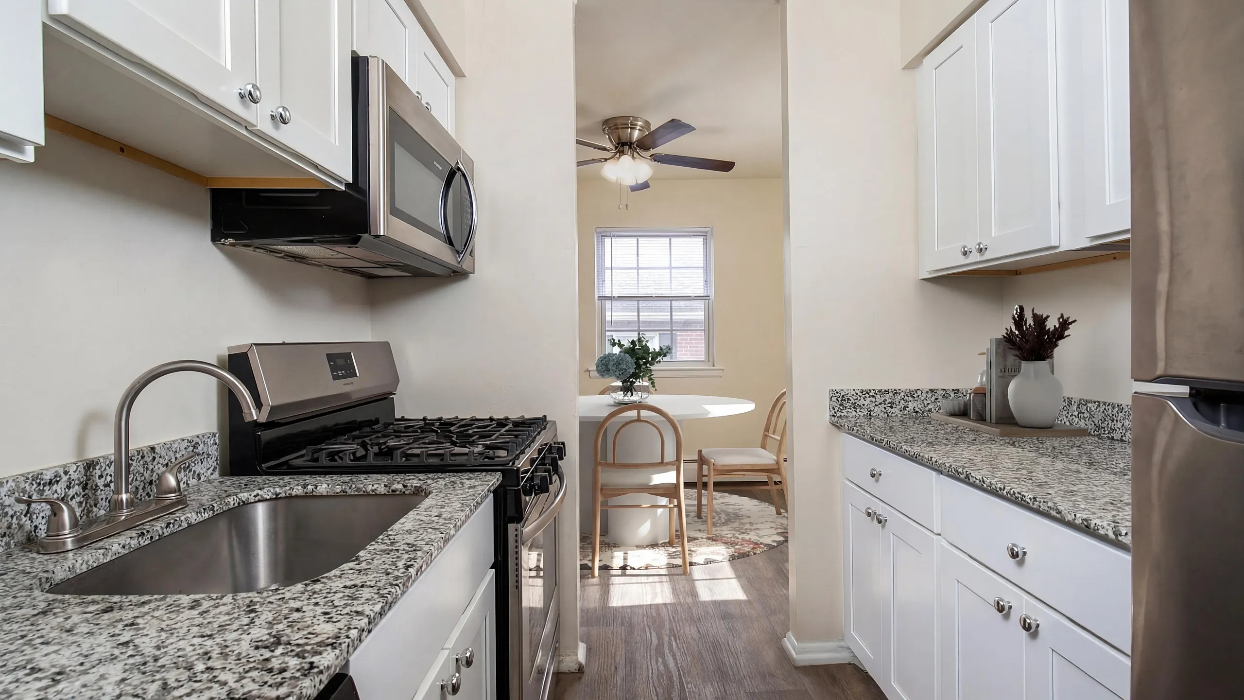 Bright and modern kitchen featuring elegant granite countertops, stainless steel appliances, and a cozy dining area with natural light.