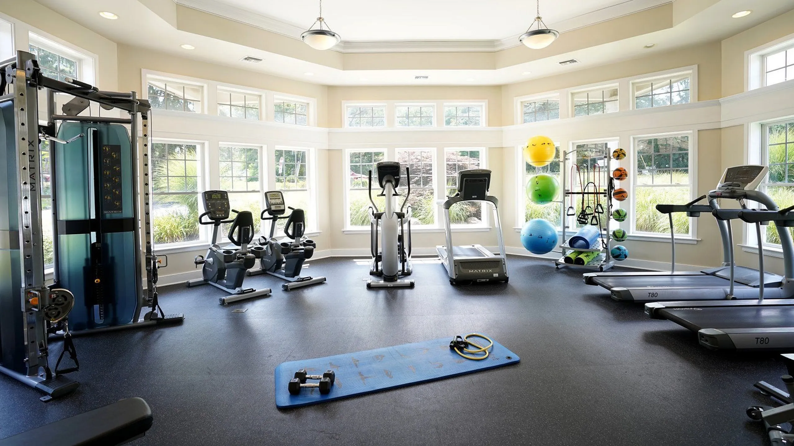 Bright, spacious gym with modern equipment, ample natural light, and a welcoming atmosphere perfect for an energizing workout.