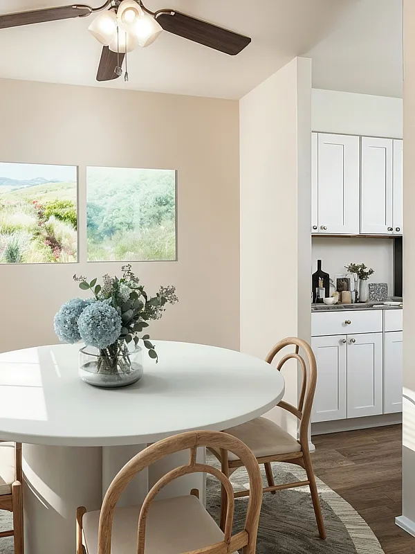 Charming dining area with elegant round table, stylish wooden chairs, and bright natural light, adjacent to a modern kitchen.