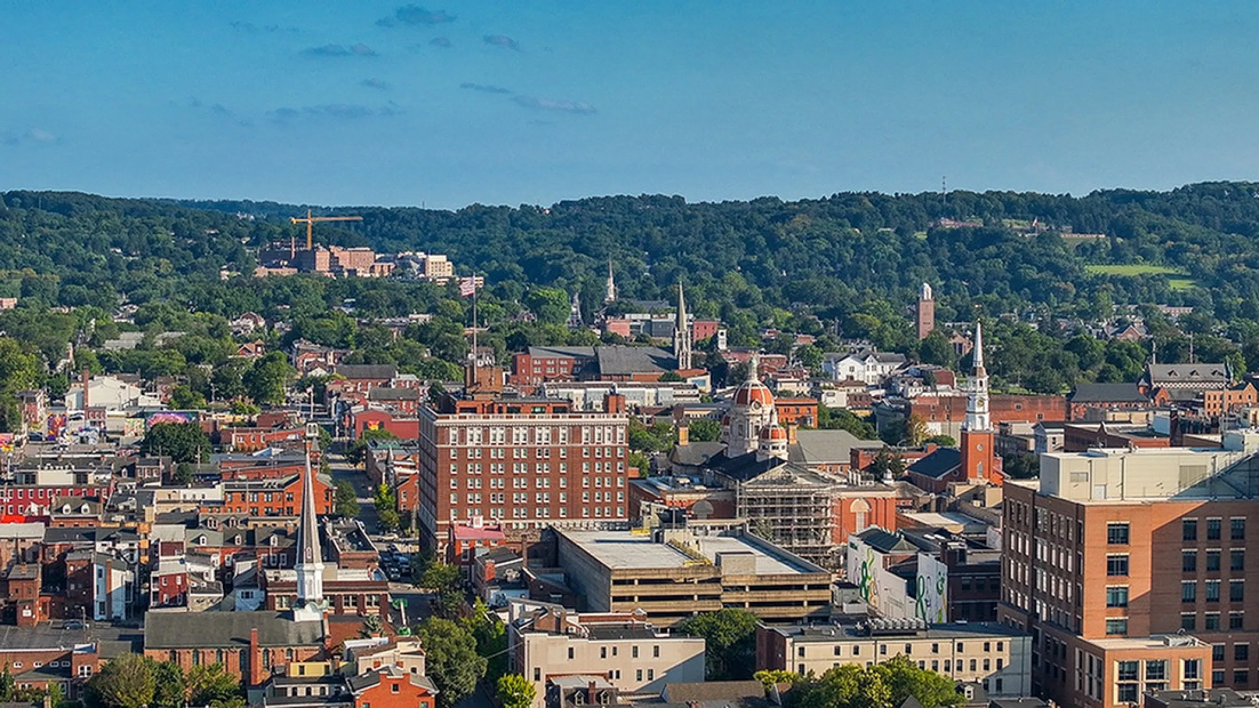 Breathtaking aerial view of a charming urban landscape with vibrant architecture and lush green hills in the background, perfect for city living.