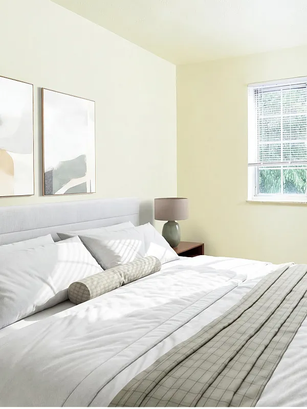 Bright and tranquil bedroom featuring a plush bed, modern artwork, and a large window with natural light.