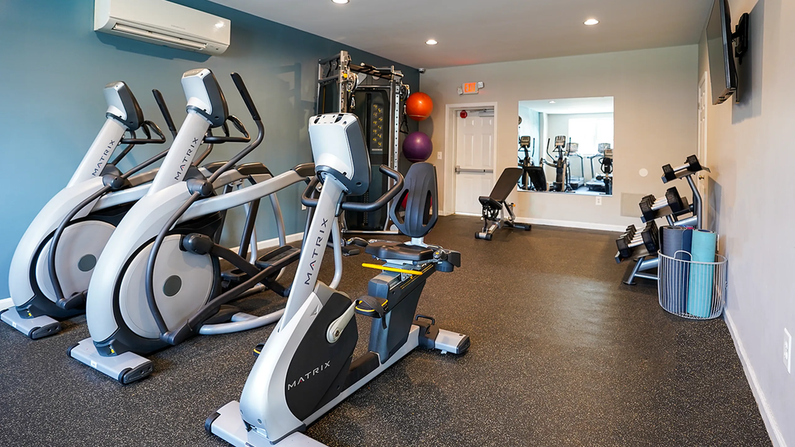 Modern fitness center with state-of-the-art exercise equipment, featuring sleek cardio machines and a vibrant, spacious workout area.