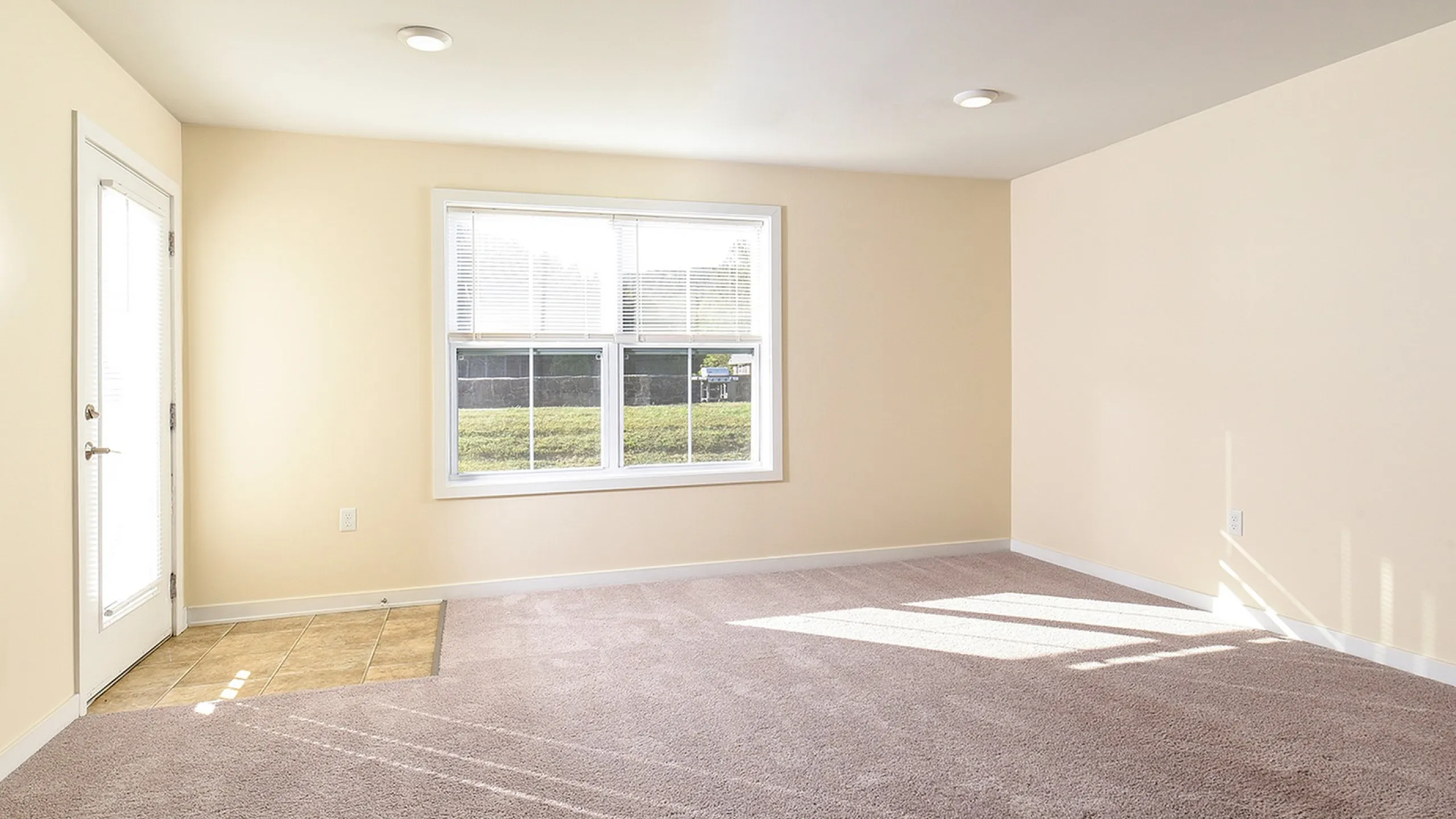 Bright and airy room featuring plush carpeting and large windows allowing natural light to flood in.