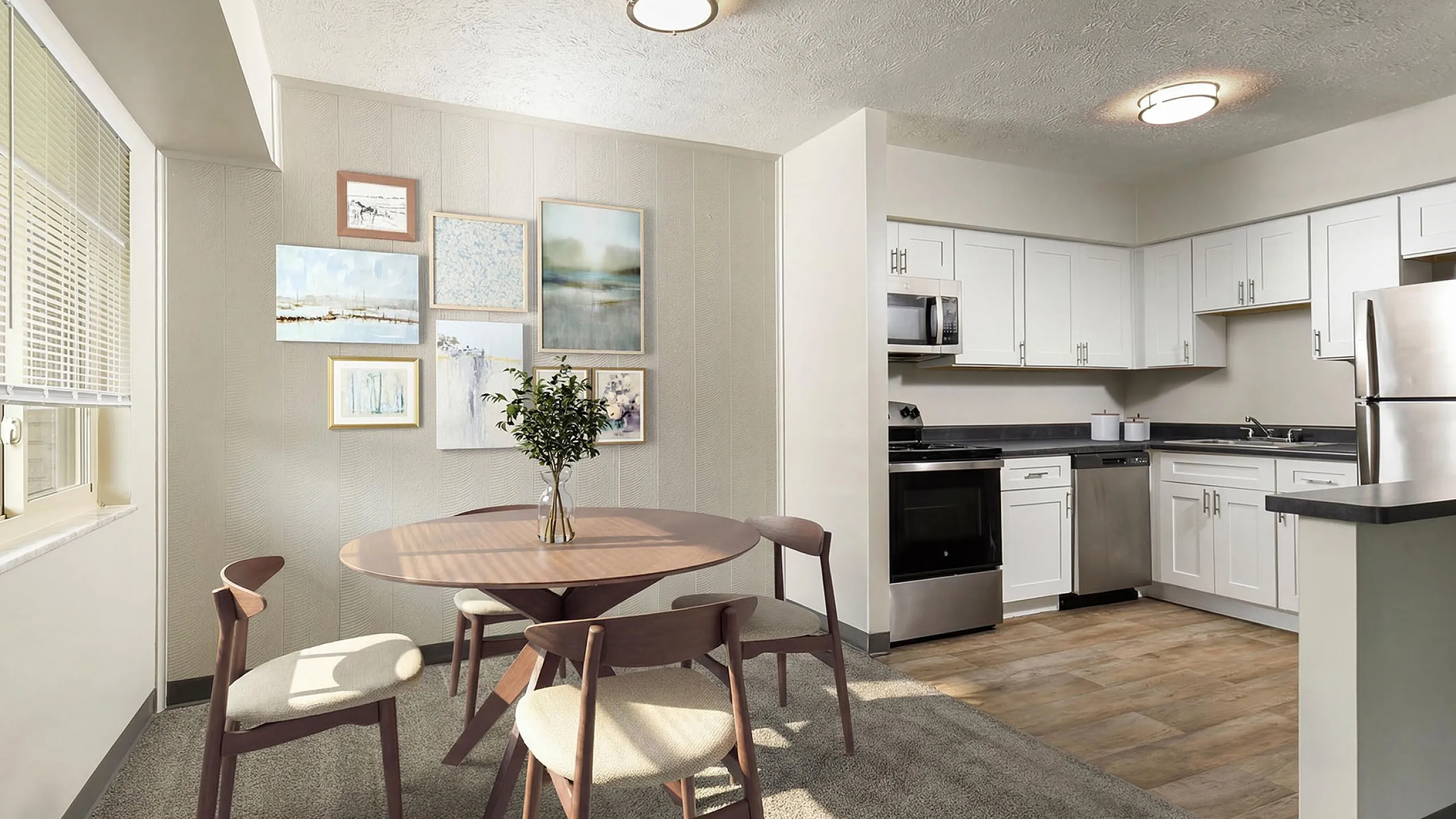 Chic dining area with modern kitchen featuring sleek stainless appliances, elegant artwork, and ample natural light.