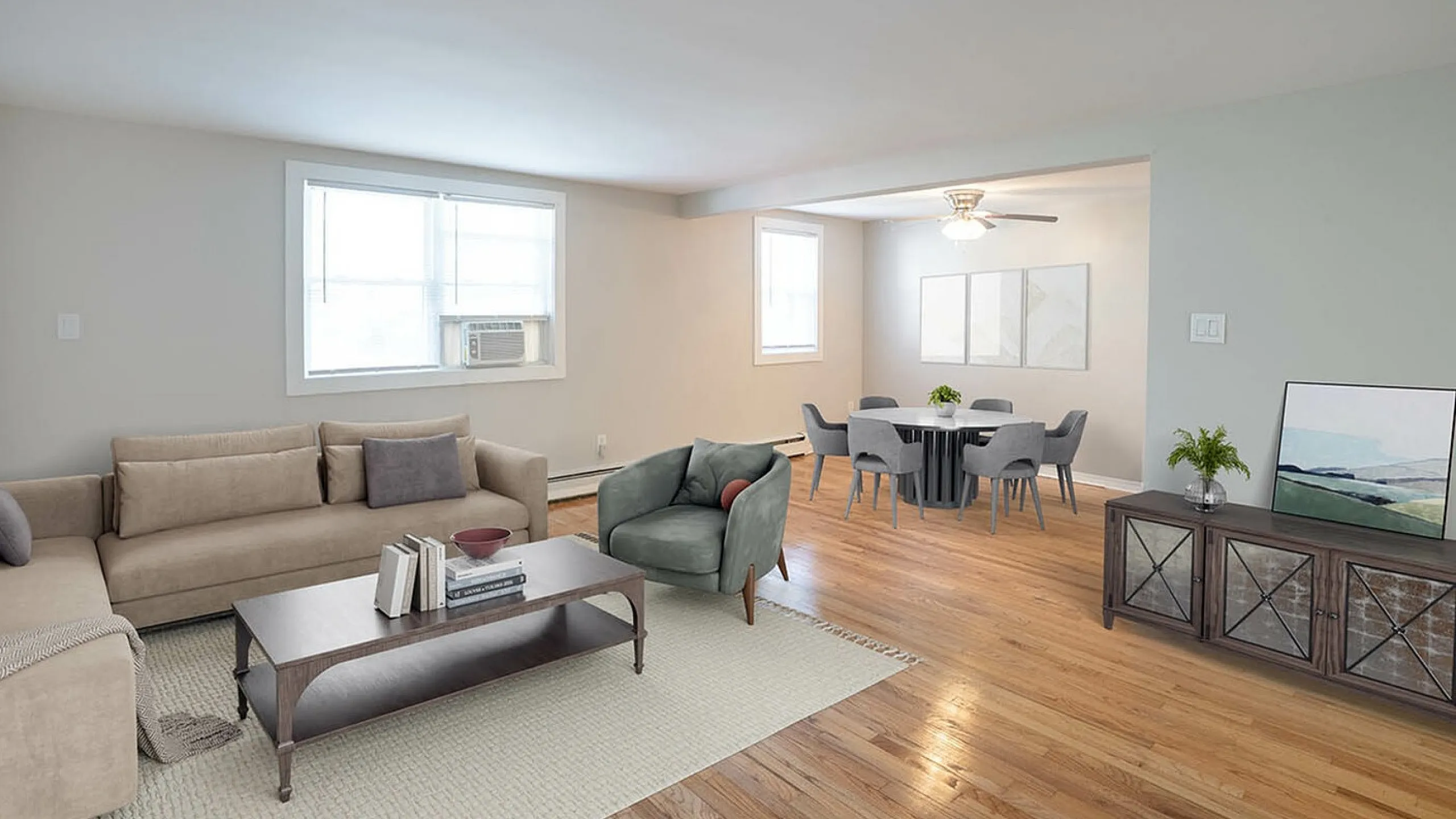Inviting, spacious apartment living room with plush beige sofa, cozy armchair, elegant dining area, and stylish decor. Bright natural lighting enhances the serene atmosphere.
