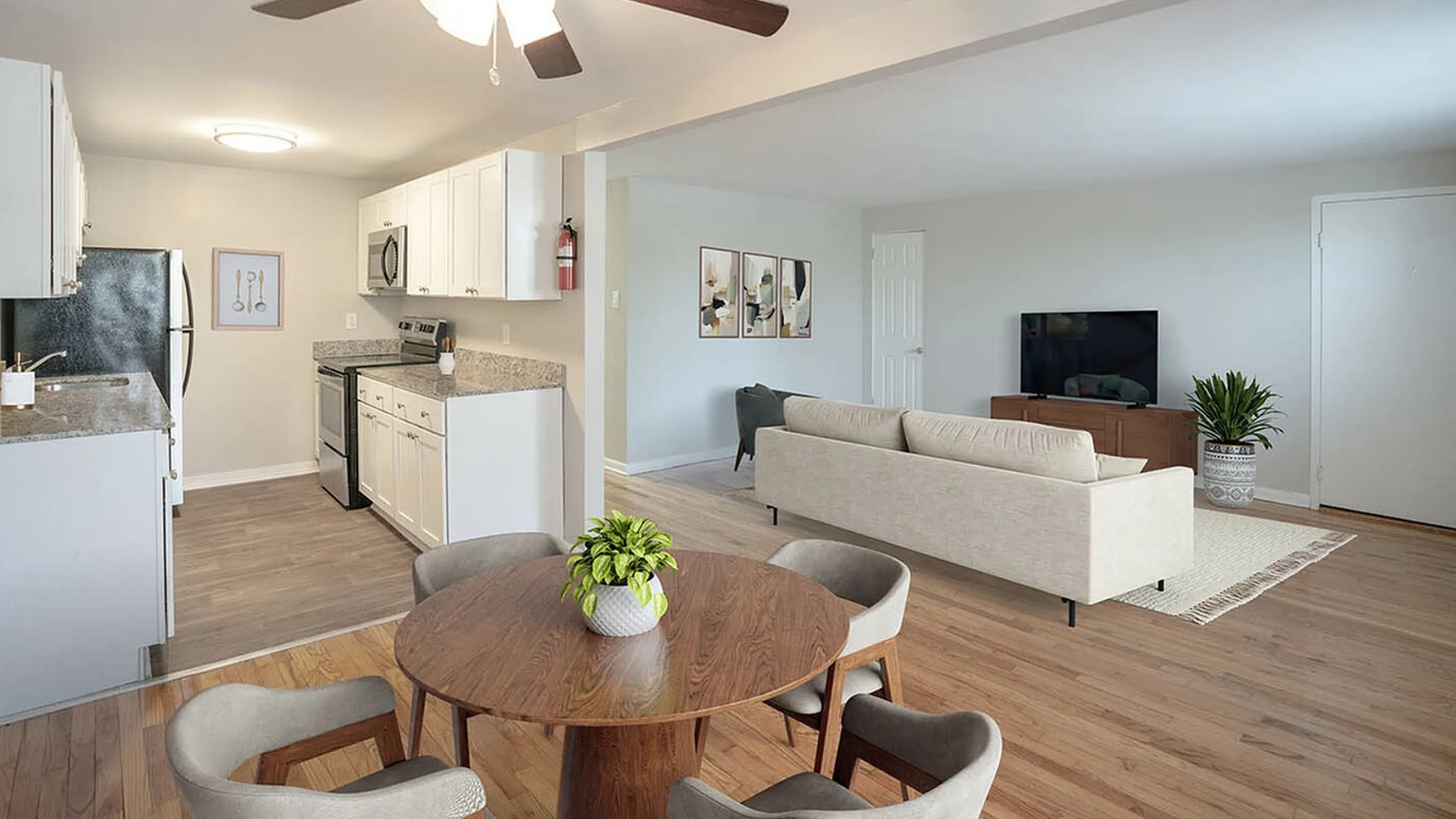 Inviting open-concept living and kitchen area with modern appliances, cozy dining space, and elegant hardwood floors.