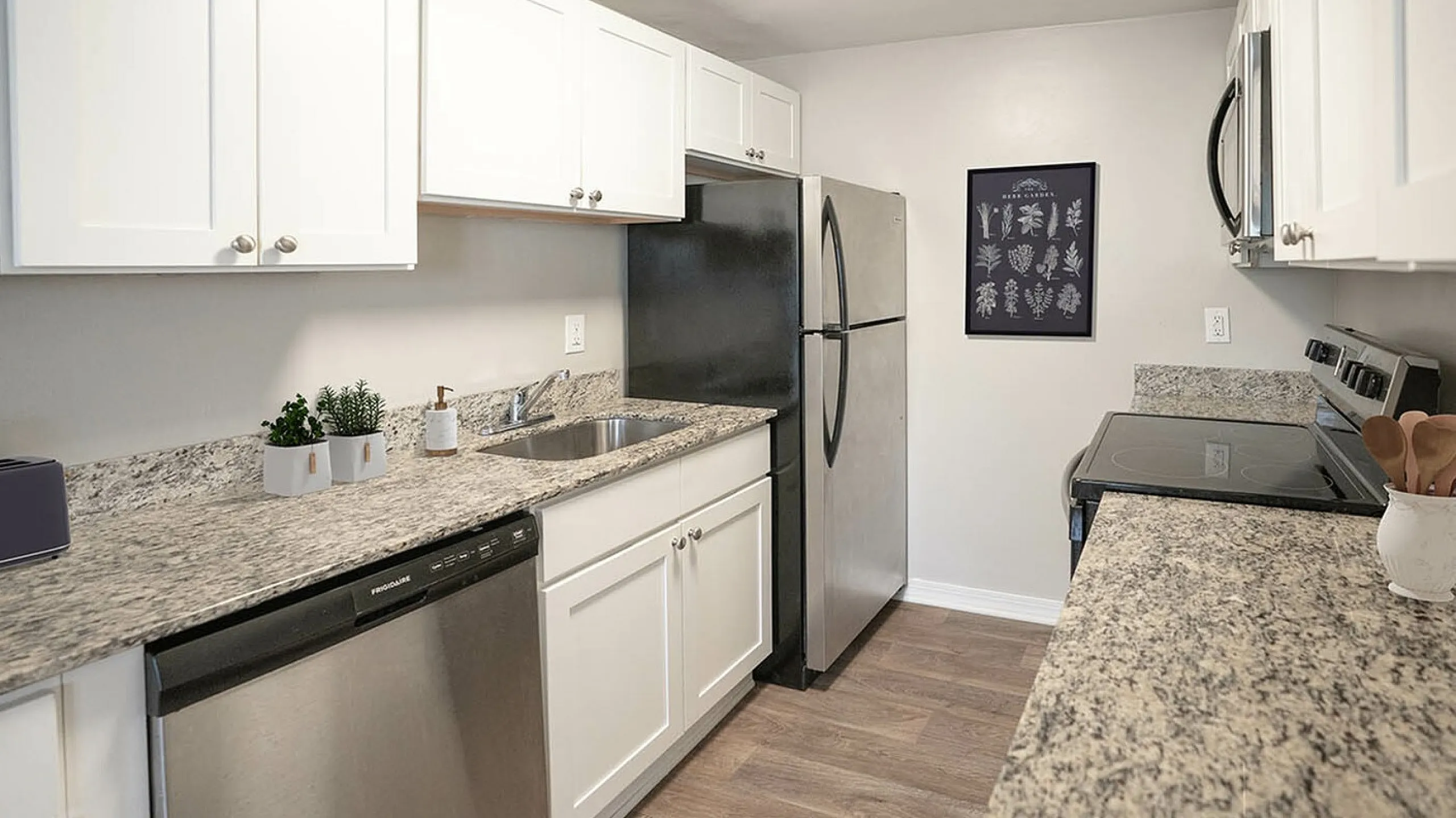 Charming kitchen with sleek granite countertops, modern stainless steel appliances, and elegant white cabinetry.