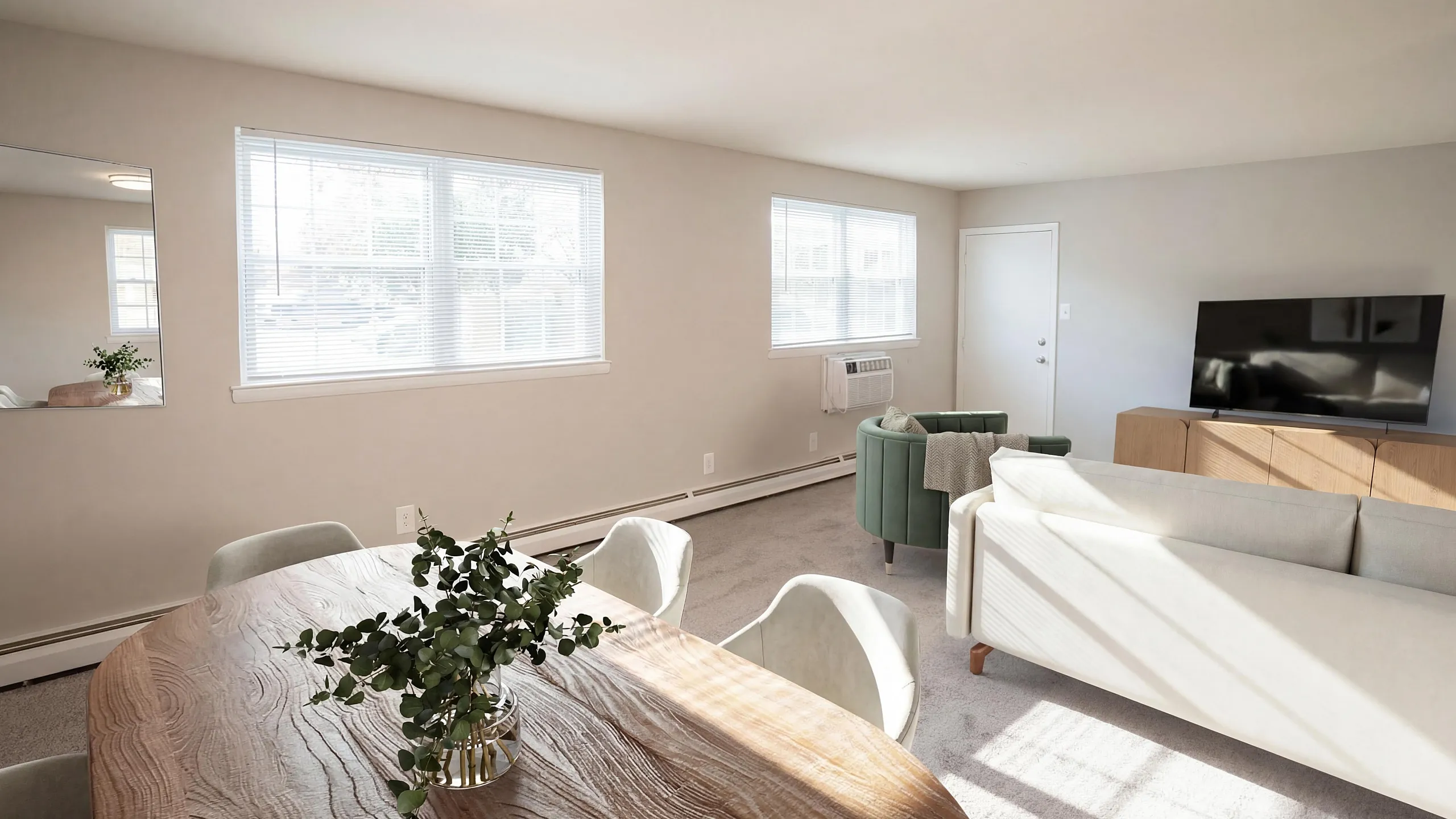 Bright and spacious living room with modern furniture, natural light, and a cozy dining area.