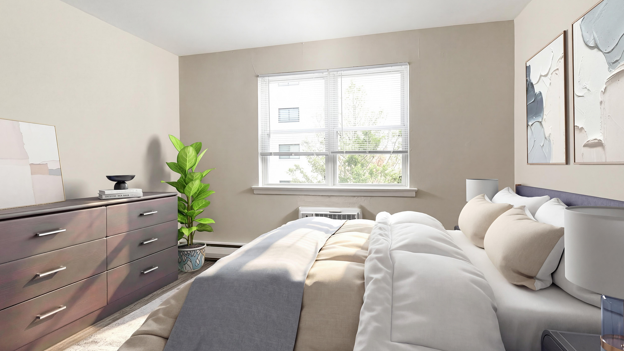 Bright and cozy bedroom with large window, elegant artwork, chic dresser, and lush indoor plant, offering a serene retreat.