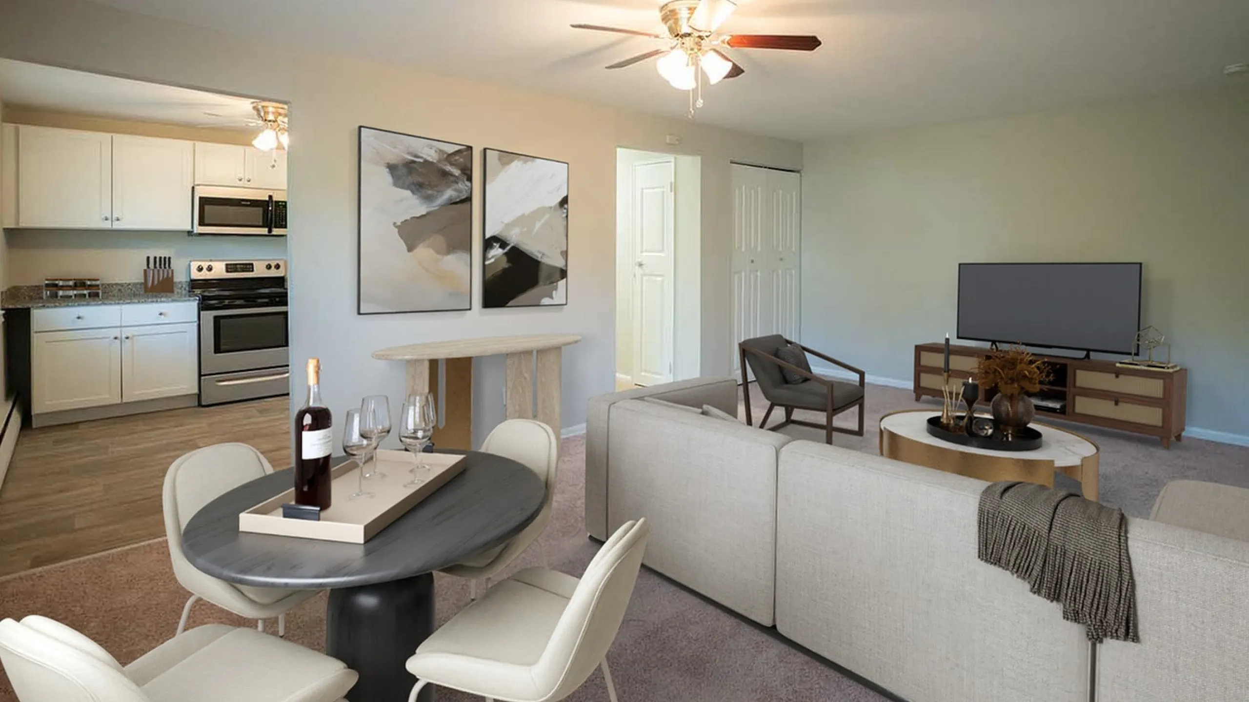Bright and modern open-concept living and dining area with elegant decor, adjacent to a sleek kitchen featuring stainless steel appliances.