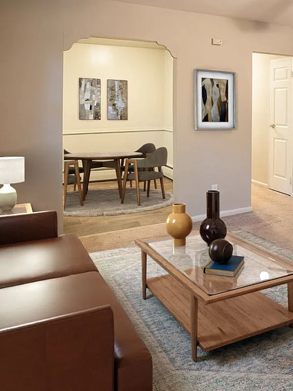 Inviting living room with elegant leather sofa, modern armchair, and stylish coffee table, leading to a cozy dining area under warm lighting, perfect for relaxed evenings.
