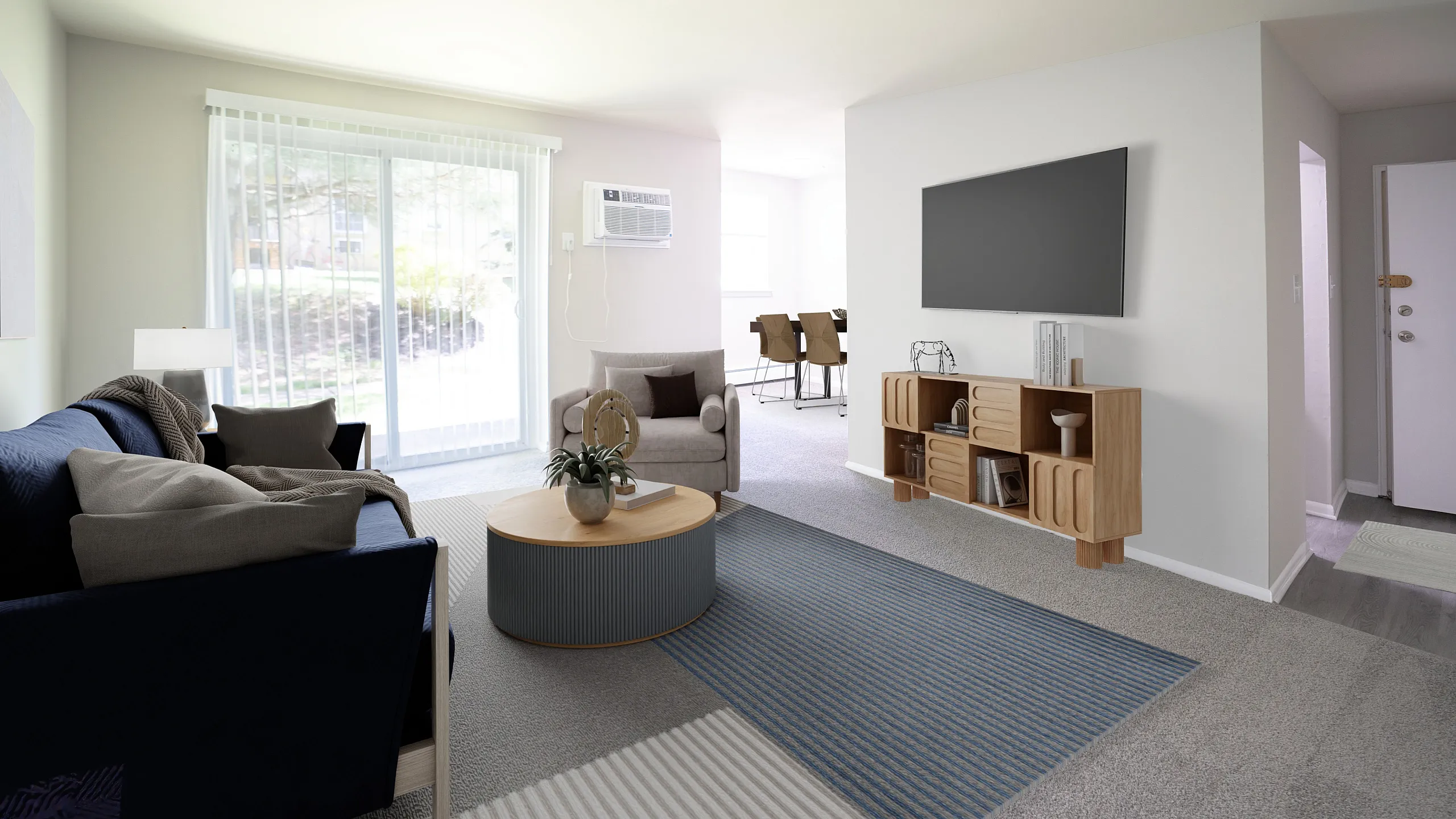 Bright, contemporary living room with plush blue sofa, modern decor, and sleek TV setup, enhanced by natural light from sliding glass doors leading to an inviting outdoor space.