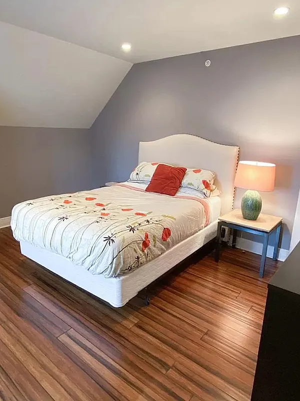 Charming bedroom with elegant wood flooring, cozy lighting, and stylish decor creating a warm and inviting ambiance.