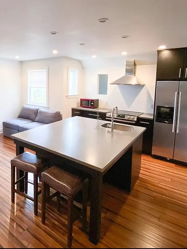 Modern open-concept loft with sleek kitchen, cozy seating, and elegant wood floors.