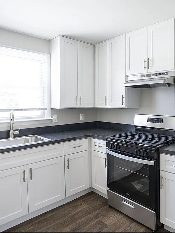 Modern kitchen featuring sleek stainless steel appliances, elegant white cabinetry, and spacious countertops, illuminated by natural sunlight.