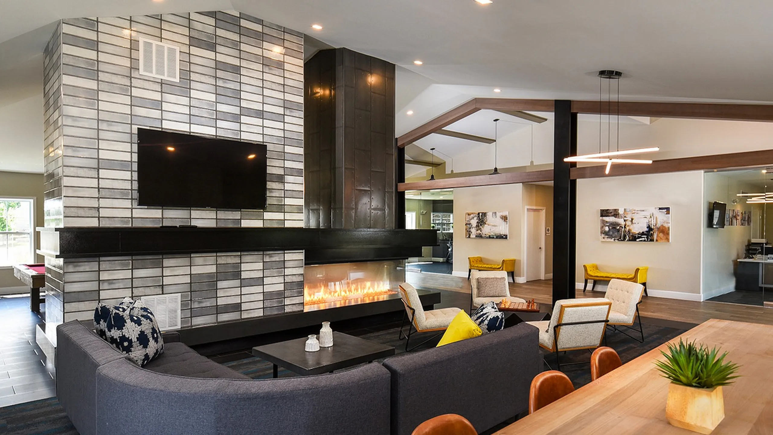 Modern living room with sleek tiled fireplace, cozy seating, and stylish lighting, ideal for relaxation and socializing.