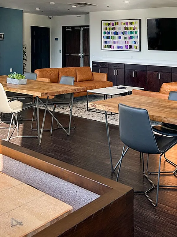 Stylish communal area featuring modern seating, large flat-screen TV, and artistic decor, perfect for social gatherings.