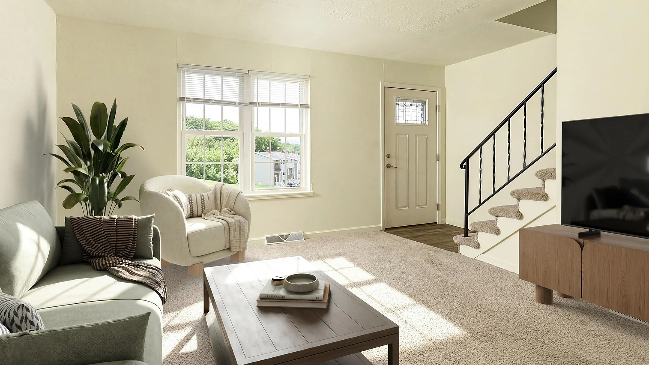 Bright and inviting living room with plush carpeting, a cozy sofa and armchair, large windows offering a scenic view, a sleek TV setup, and stylish decor. Ideal for relaxation and entertainment.